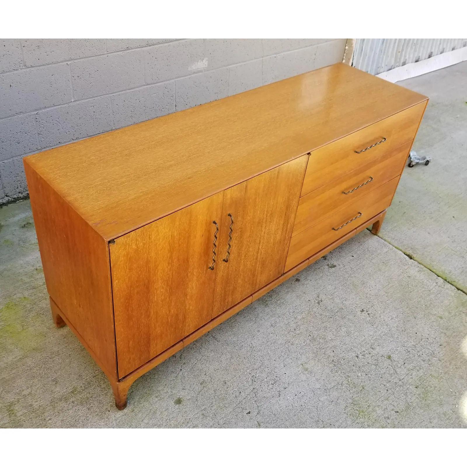 Mid-Century Modern credenza designed by John Keal for Brown-Saltman, circa 1950s. Beautiful golden mahogany wood grain with original bent wire hardware. Solid construction using quality materials.