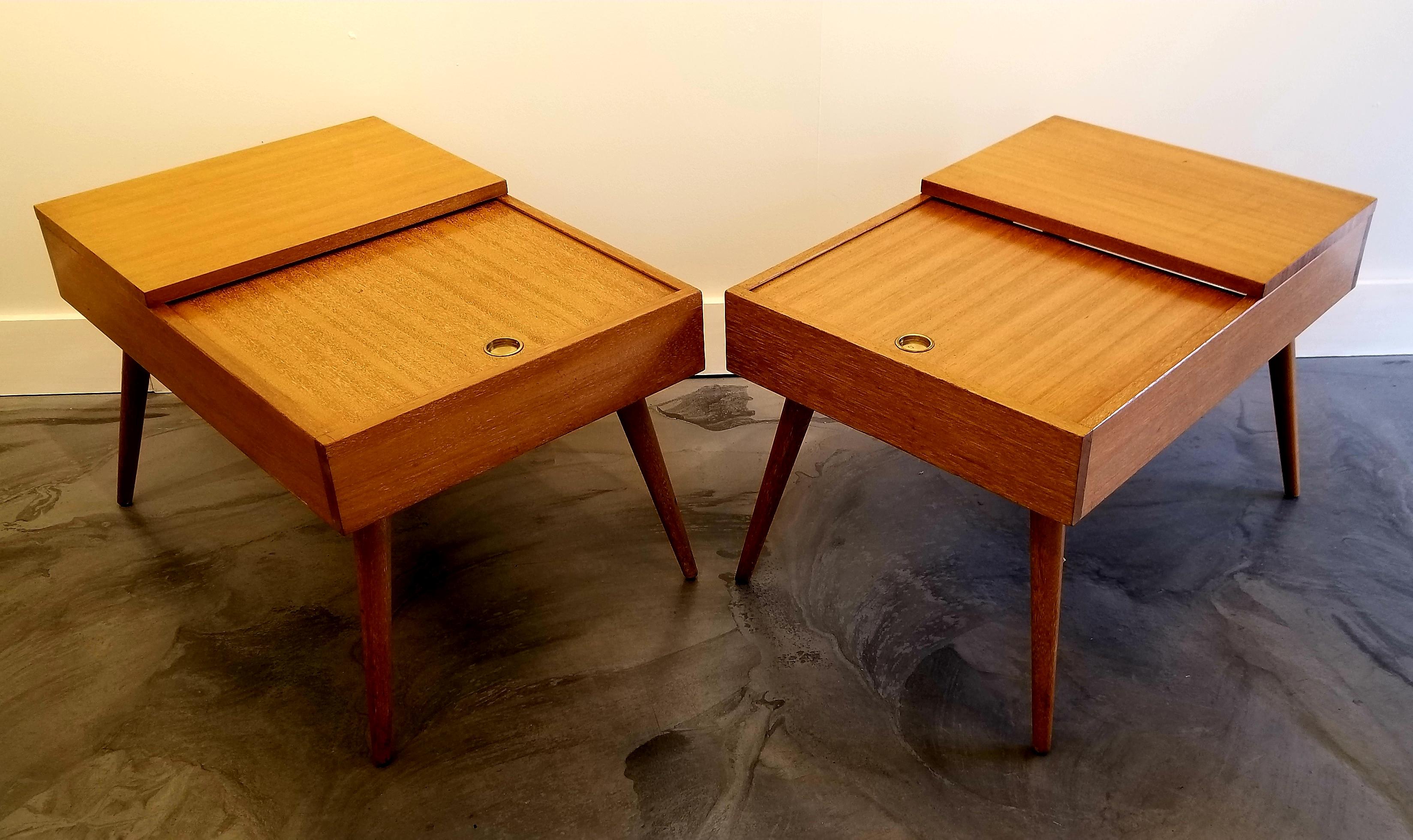 A pair of Mid-Century Modern golden mahogany end tables designed by John Keal for Brown Saltman of California, circa 1950s. Classic conical or peg leg construction with sliding door for hidden storage. Beautiful detail of wood grain with original