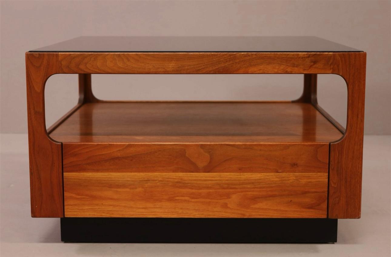 A beautiful walnut and smoked glass  square side table designed by John Keal for Brown Saltman. It features one drawer. There is a Brown Saltman Red Decal Label on the inside. It is pictured in our gallery with the matching coffee table and other