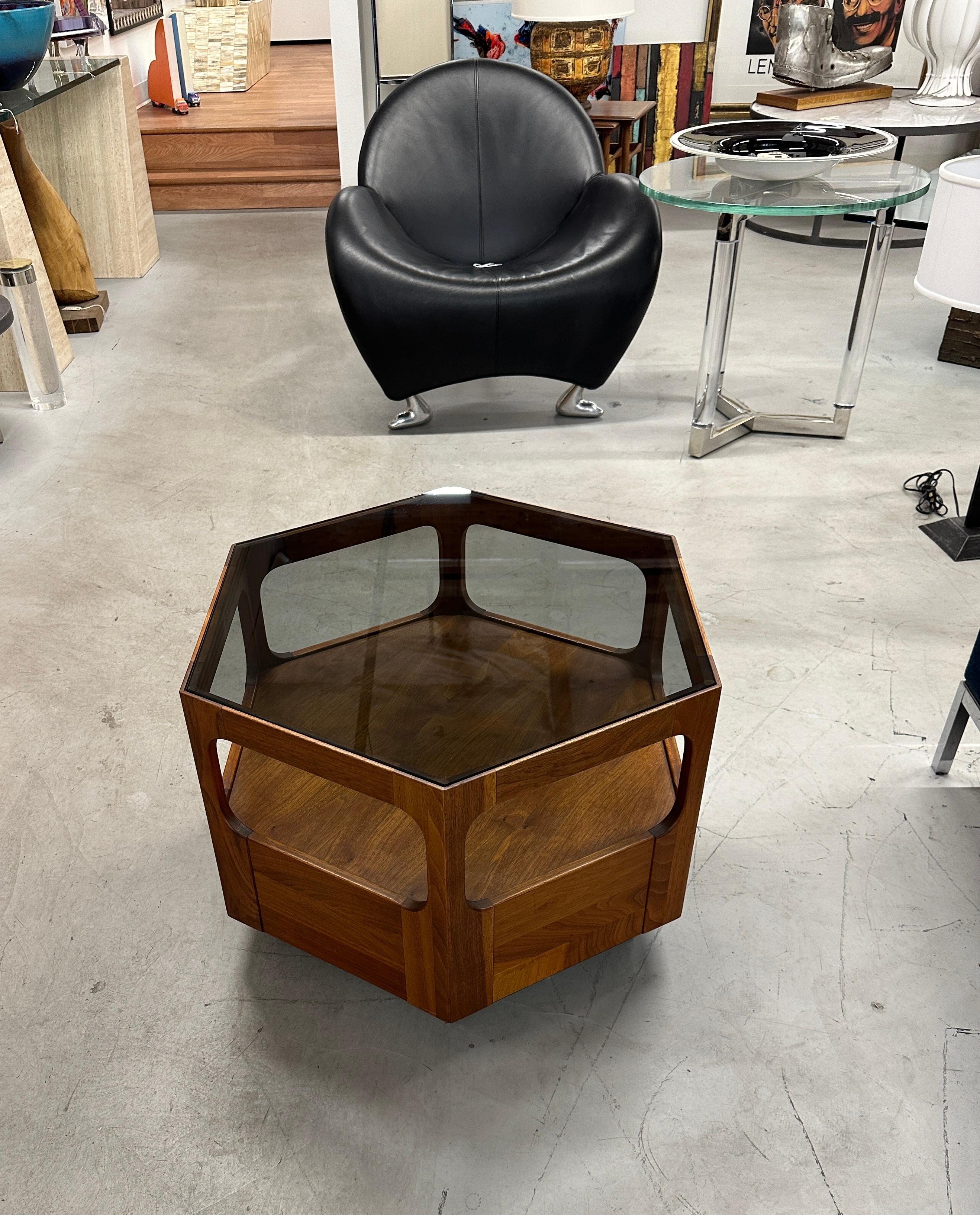 A beautiful walnut and smoked glass 6 sided hexagonal side table designed by John Keal for Brown Saltman. It is pictured in our gallery with the matching coffee table and other side table from the same lovely Palm Spring estate. There is a Florence