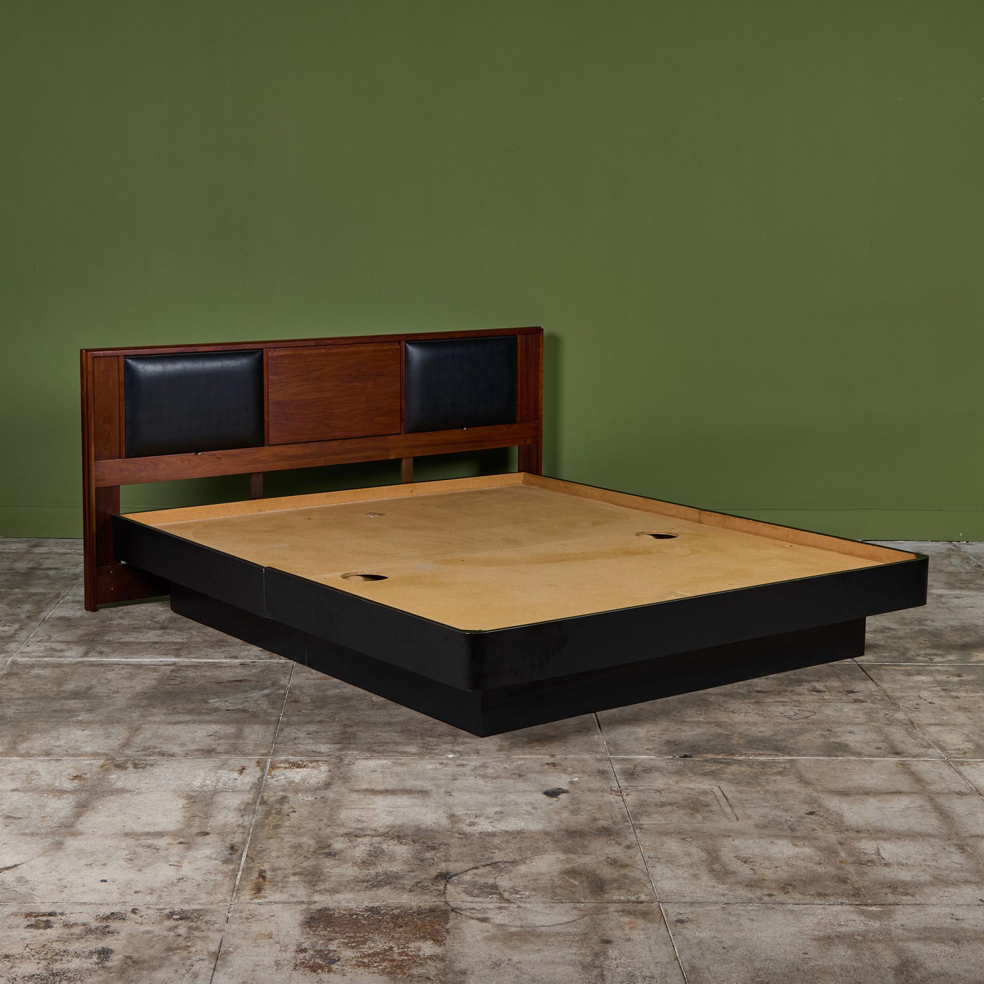 Tête de lit king size par John Keal pour Brown Saltman c.1960s, USA. La tête de lit en noyer est dotée d'appuis-tête en Naugahyde noir escamotables et d'une mince table centrale escamotable. La tête de lit est accompagnée d'un cadre de lit king size