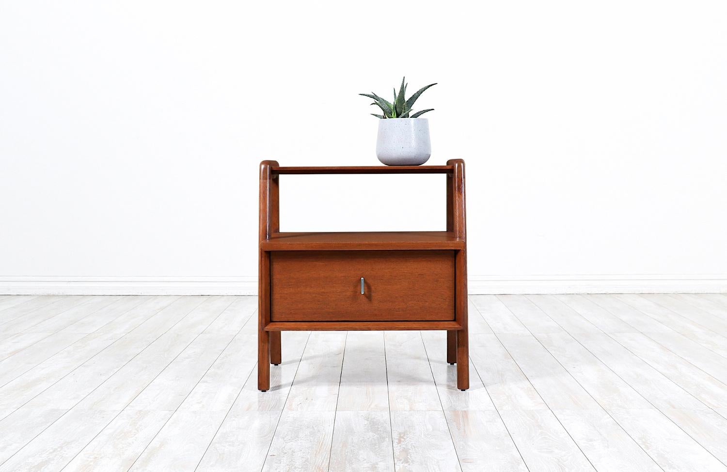 Elegant modern nightstand designed by John Keal for Brown Saltman in the United States circa 1950s. This fabulous nightstand is built on solid walnut-stained mahogany wood featuring a single sculpted drawer to store bedside essentials, with its