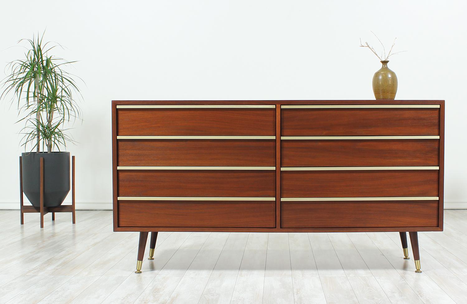 Spacious dresser designed by John Keal for Brown Saltman in the United States circa 1950s. This six-drawer dresser features a walnut wood case with long, brass pulls on each of the dovetail-constructed drawers. This exceptional dresser sits on four