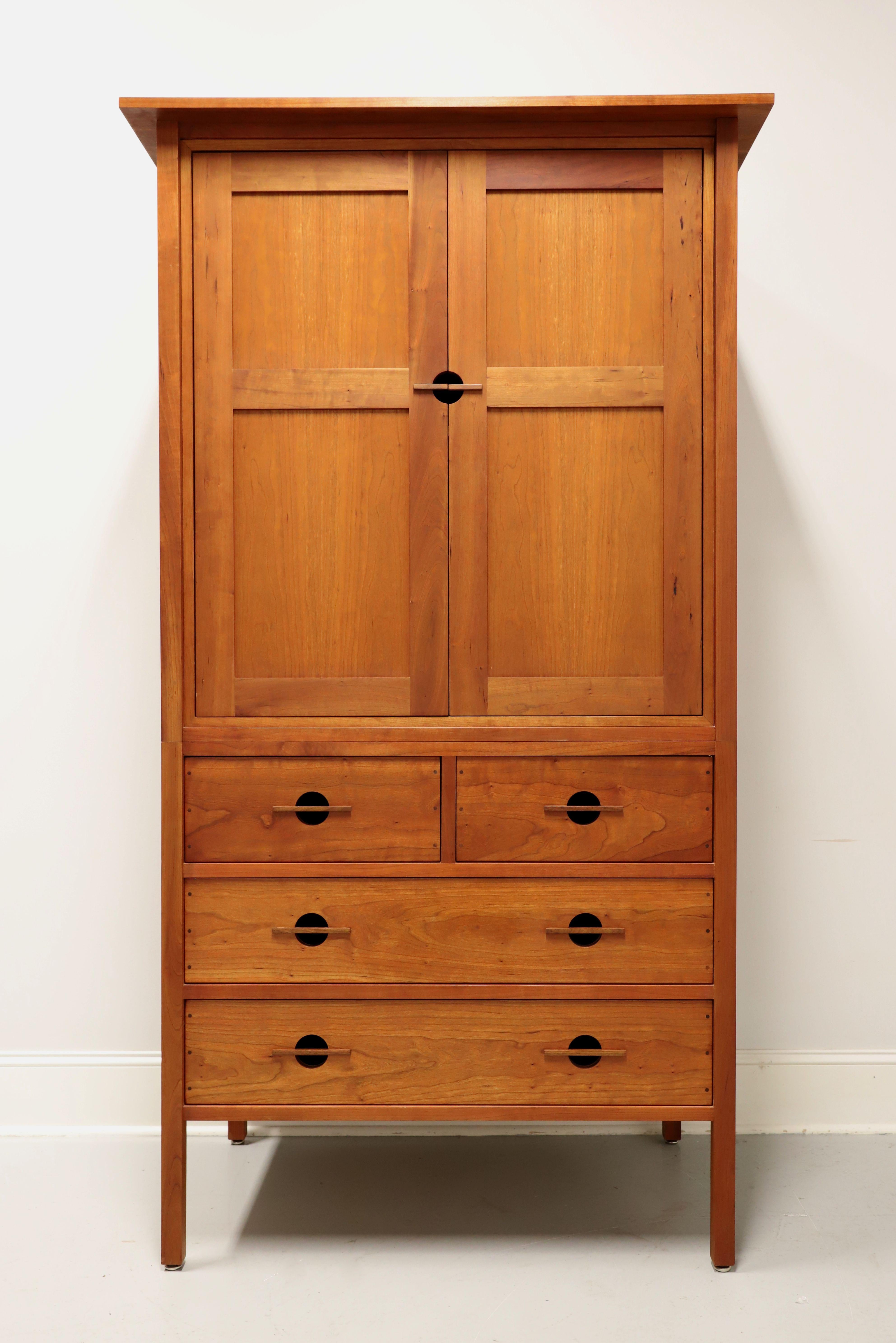 A Mission / Arts & Crafts style wardrobe by John Kelly Furniture, the J-36A Armoire Wardrobe, from their J1 Series. Solid black cherry with black walnut peg detailing to drawers, square edge overhanging top, plank style panel doors, signature