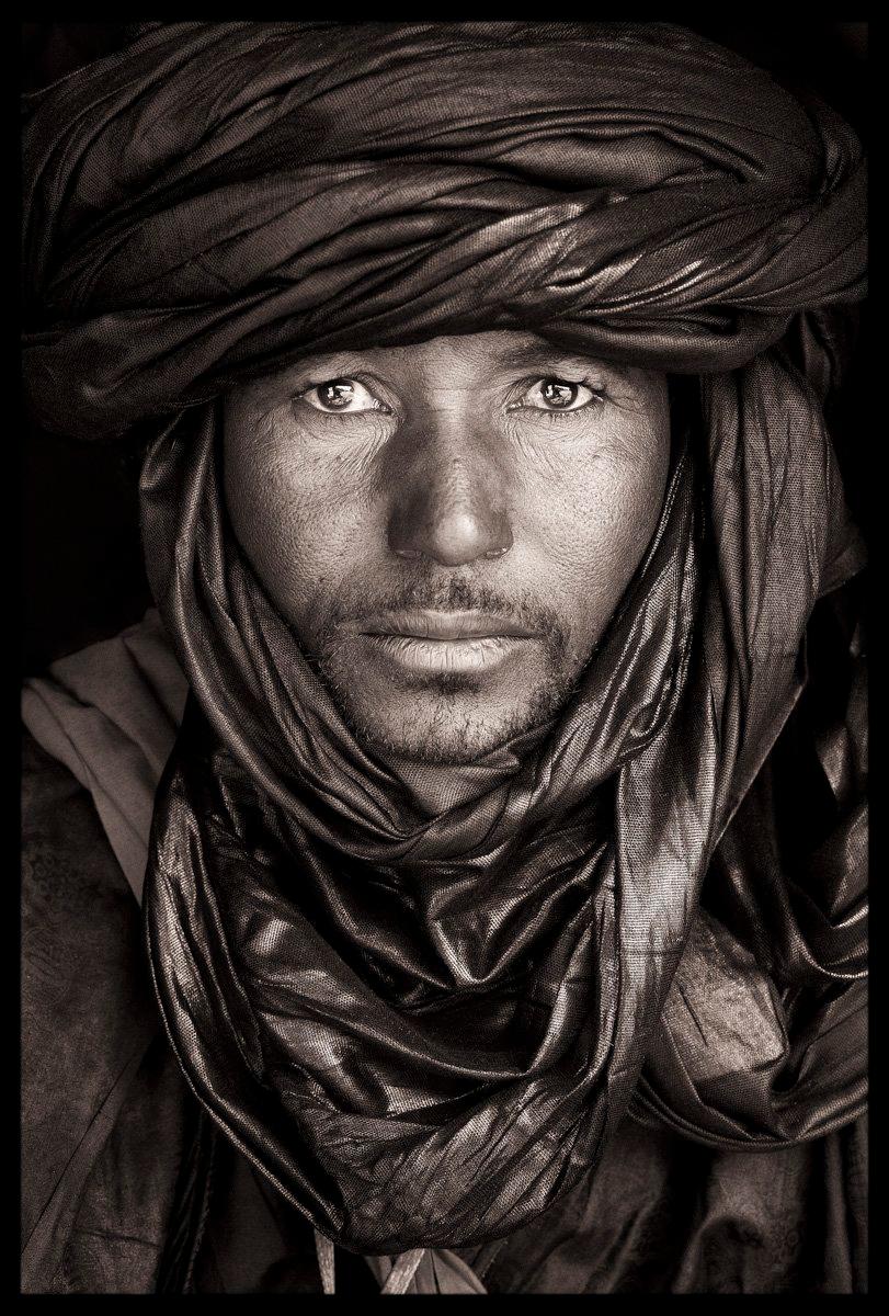 A Tuareg man 80 kilometres north of Timbuktu in the desert camp of Essakane. He was wearing a beautiful red metallic turban characteristic of the Tuareg from this part of Northern Mali.

John Kenny’s work is all shot on location in some of the