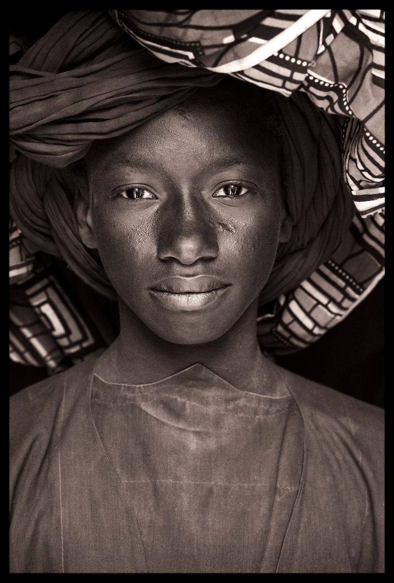 This young Fulani boy with his huge turban wrap was wandering through the backstreets of the great mosque in Djenne, an amazing structure which is the largest mud building on earth. He was returning from the huge Monday market, a site of trading