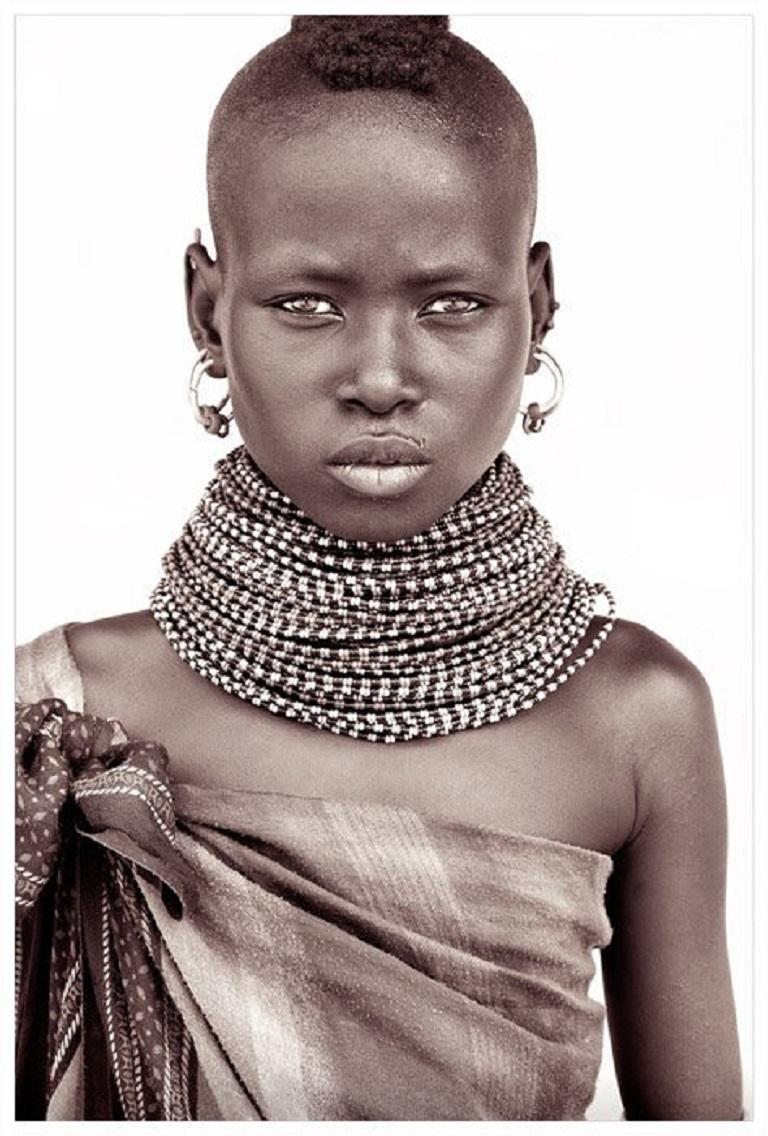 A young Rendille girl

A return to Kenya.  On this trip John took a different approach to lighting.  Building makeshift studios from locally acquired white sheets held up by four warriors and their spears!  The suffuse light allows John to capture a