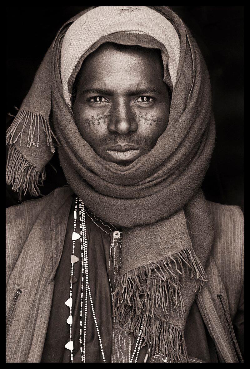 The man was sat in the shade during a huge village market in a place called Golondi in Niger.  We drank the salty, sweet tea that the nomads of the Sahel and Sahara so adore.

His distinctive facial tattoos marked him out as a true Fula nomad, an