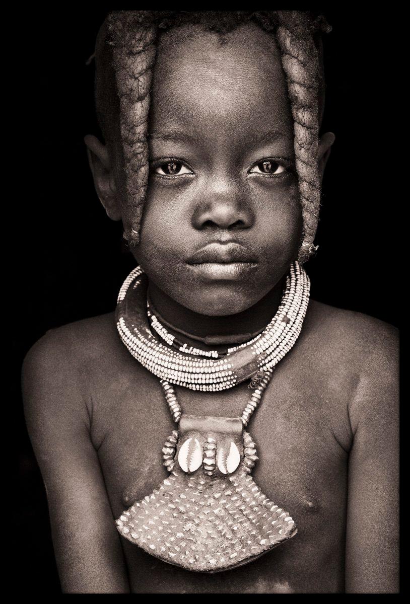 A young Himba child from Namibia
John Kenny’s work is all shot on location in some of the remotest corners of Africa. His images are all taken with natural light and his subjects in their day to day attire.

The C-type prints are mounted with an