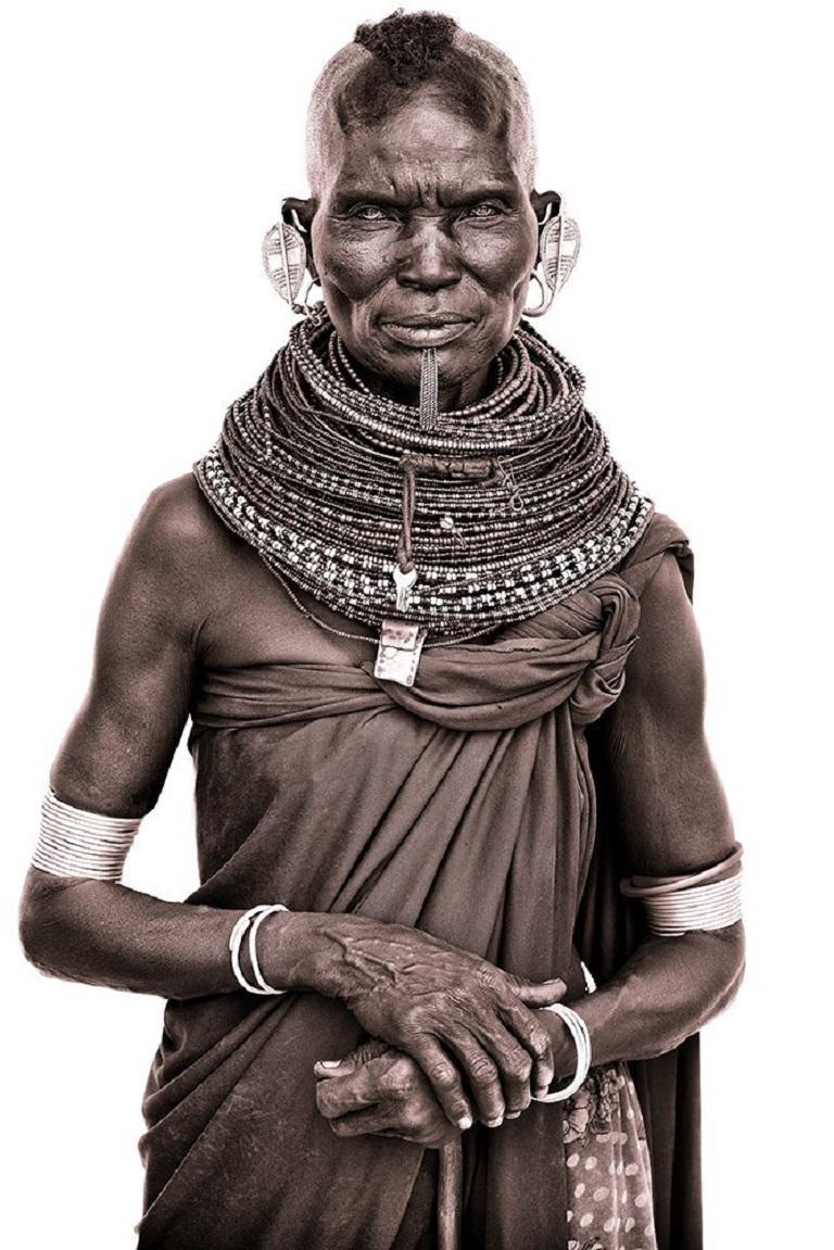 A Turkana elder in Northern Kenya

John uses simple natural light and builds primitive makeshift studios from locally acquired white sheets! The suffuse light allows him to capture a remarkable level of detail. His subjects calm demeanor belies the