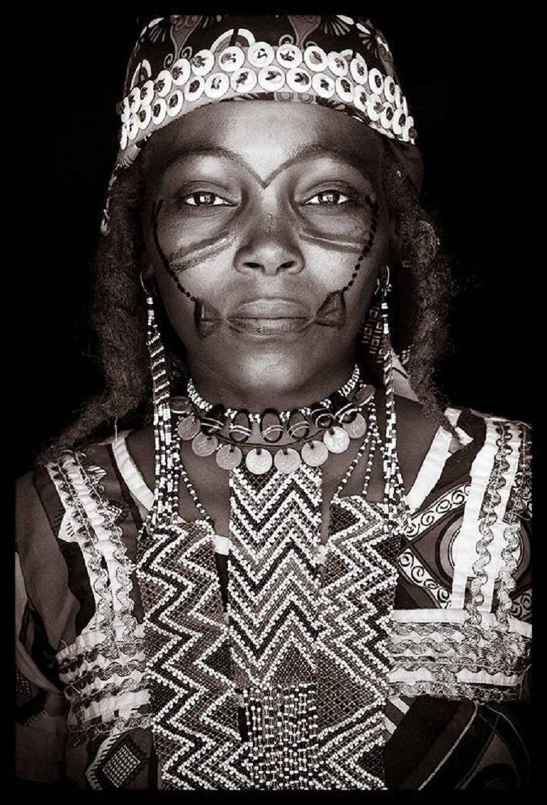 Konbaki - ein Porträt einer Fula-Frau aus Niger in Afrika.

John Kennys Arbeiten werden alle vor Ort in einigen der entlegensten Ecken Afrikas gedreht. Seine Bilder sind alle mit natürlichem Licht und in der Alltagskleidung seiner Motive