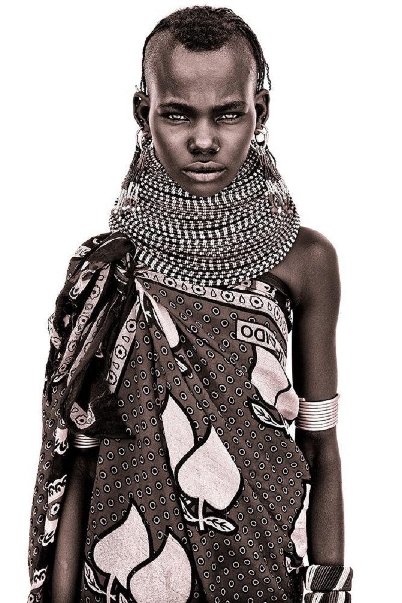 Una giovane ragazza Turkana

I. Johns utilizza una semplice luce naturale e costruisce studi primitivi di fortuna con lenzuola bianche acquistate localmente! La luce soffusa gli permette di catturare un notevole livello di dettaglio. Il contegno
