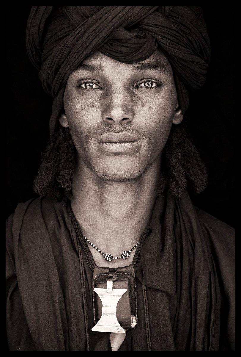 Das Porträt eines jungen Wodaabe-Mannes aus der Stadt Bororo in Niger. Bororo wird oft als die "Hauptstadt" seines Volkes angesehen. Der Name Bororo wird auch von anderen Kulturen in Niger verwendet, um diese Gruppe von Menschen zu beschreiben.

Er
