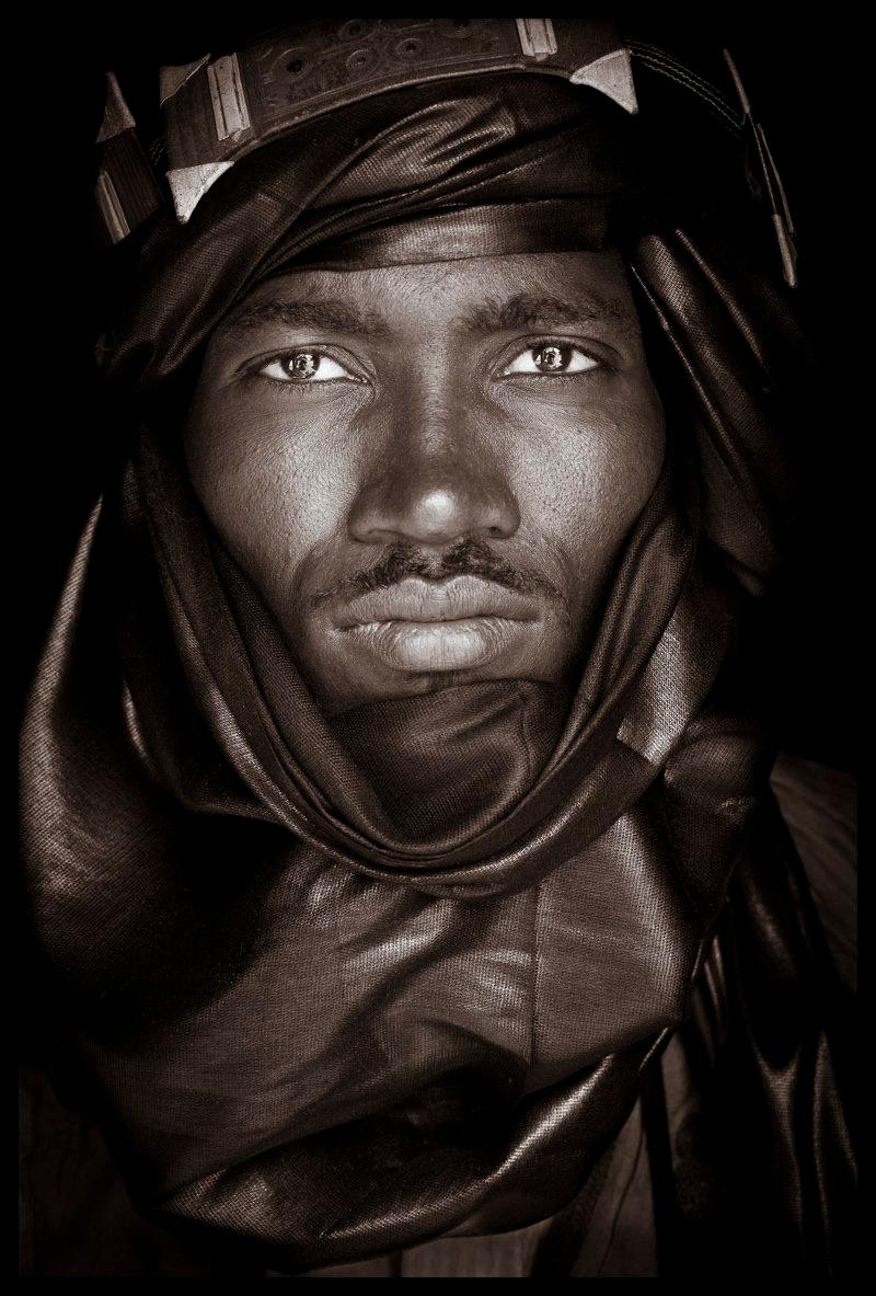 A Tuareg warrior from Mali.

John Kenny’s work is all shot on location in some of the remotest corners of Africa. His images are all taken with natural light and his subjects in their day to day attire.

The C-type prints are mounted with an acrylic