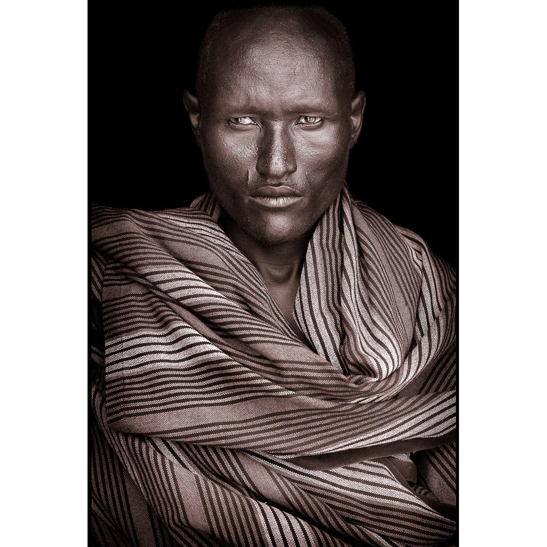 Ein Porträt von Acuan, einem Turkana-Mann aus Nordkenia im Jahr 2019.

John Kennys Arbeiten werden alle vor Ort in einigen der entlegensten Ecken Afrikas gedreht. Seine Bilder sind alle mit natürlichem Licht und in der Alltagskleidung seiner Motive