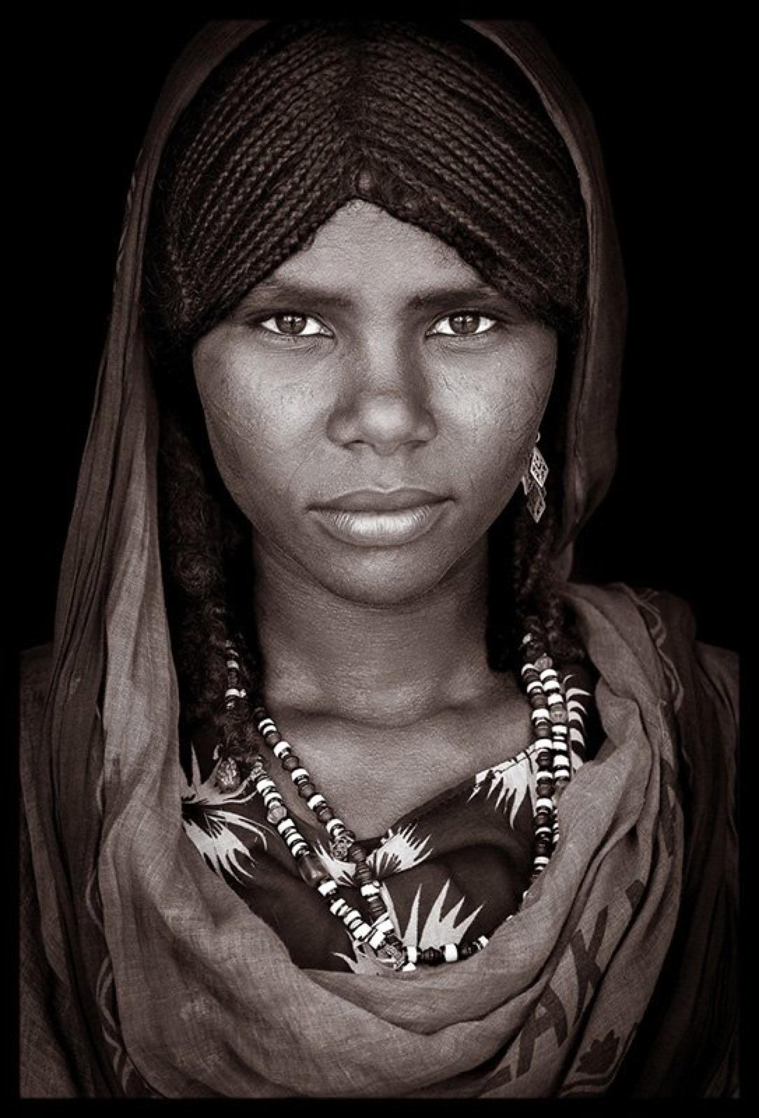 Una joven de la cultura Afar
El trabajo de John Kenny está rodado en algunos de los rincones más remotos de África. Sus imágenes están todas tomadas con luz natural y con su atuendo cotidiano.

Las impresiones tipo C se montan con un soporte facial