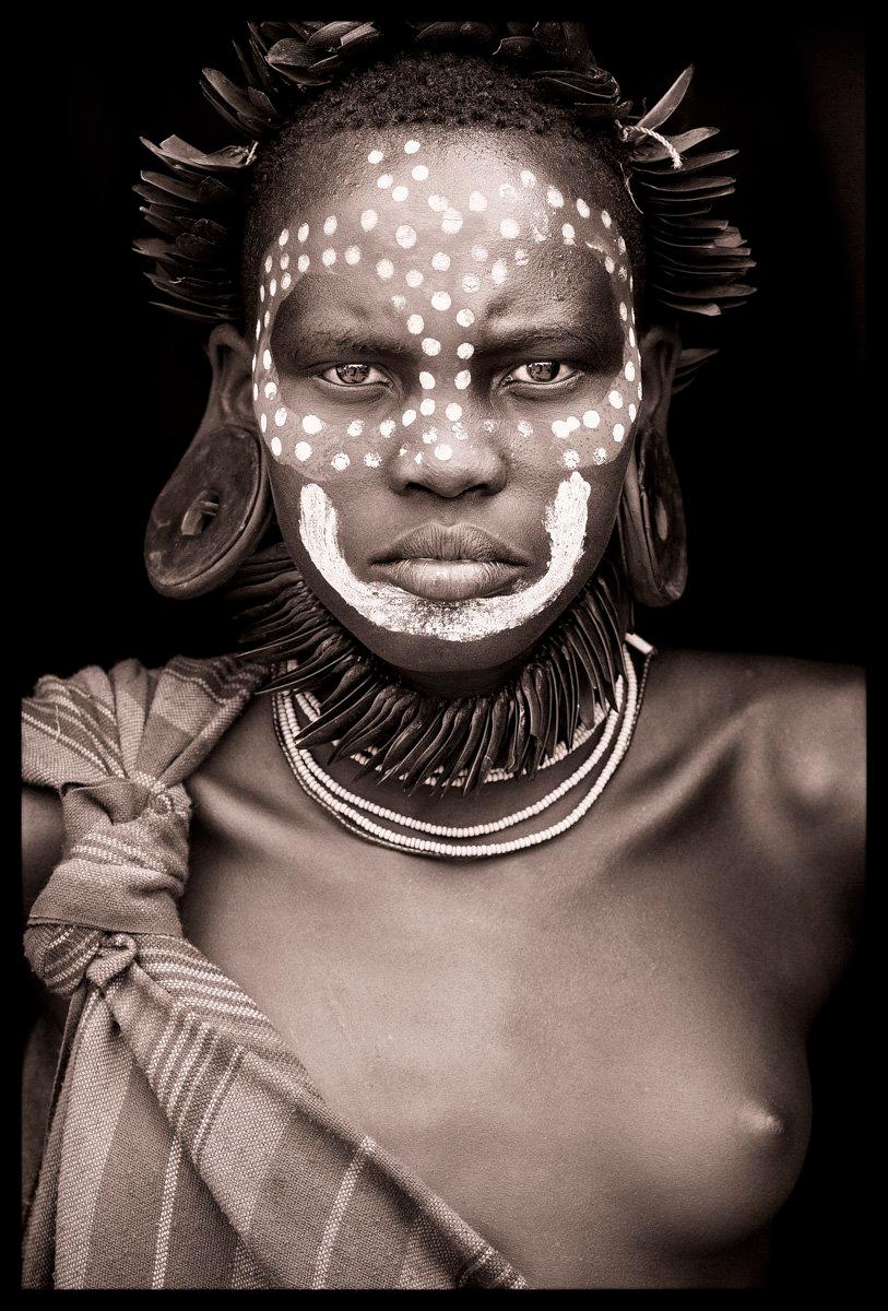 A young girl from one of the few Mursi villages in Mago National Park, in the lower Omo valley. The Mursi are often engaged in flood retreat cultivation around two main rivers: the Omo and the Mago. This does not tie them to a single location as
