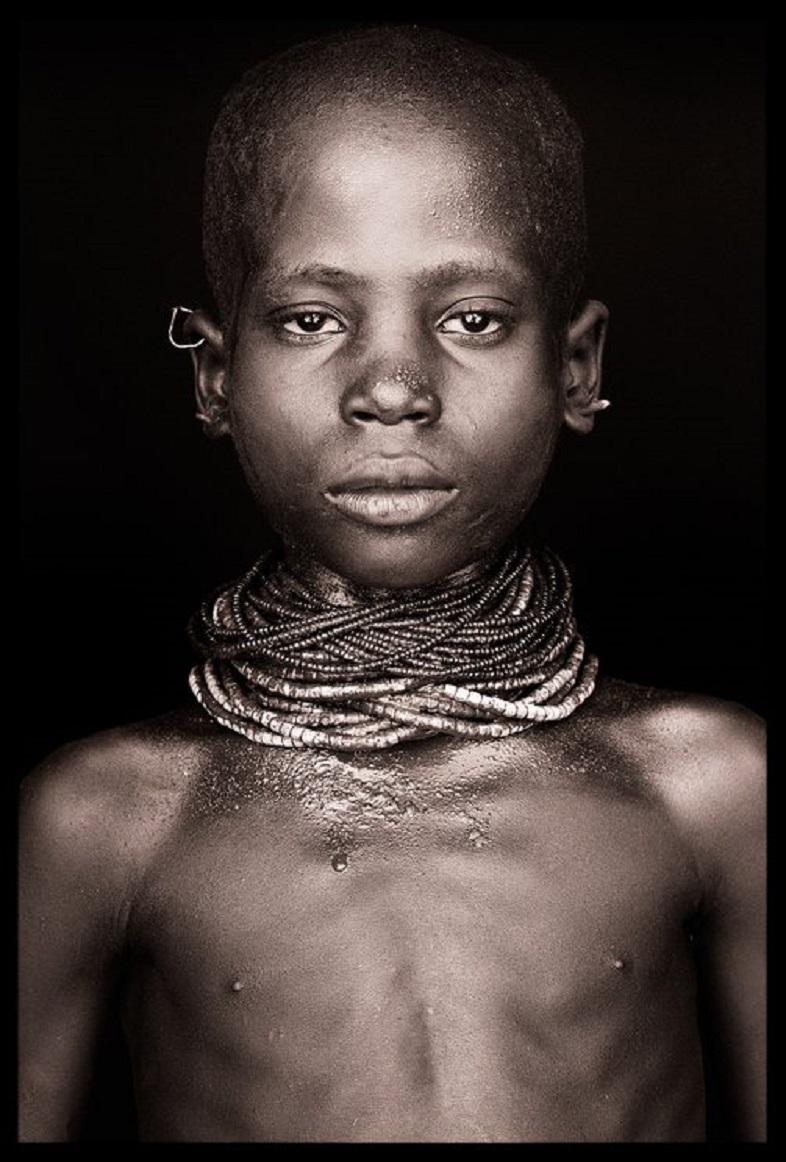 It was boiling hot as I walked the 3 kilometres to the Nyangatom village of Kangatan.  A shimmering heat haze  and occasional dust devils  whipped fine powder across the flat, bare landscape.  The boy had prominent scarification on his stomach as a