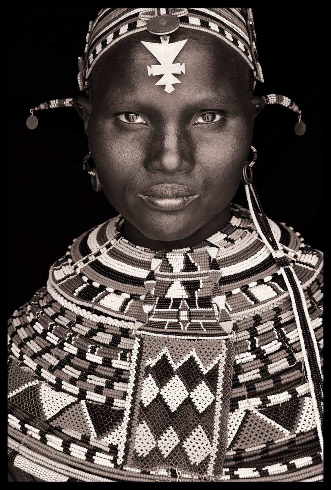I met this young married Samburu in the middle of a busy market in western Kenya. She was with a group of  young women browsing the wooden stalls dotted across the dusty red earth in the lowlands of the Matthew’s Range. In Samburu communities young
