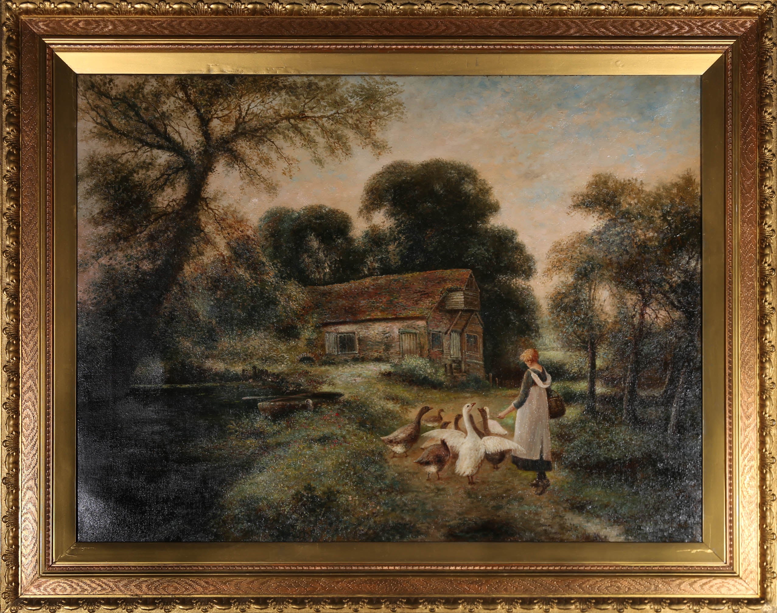 A charming turn of the Century oil scene, showing a young girl herding a flock of geese with a stick, outside of a thatched cottage in a leafy woodland. The artist has signed to the lower left corner and the painting has been presented in a fine