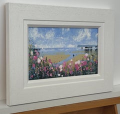 Paisaje costero con figuras en la playa y flores silvestres rosas Campiña inglesa