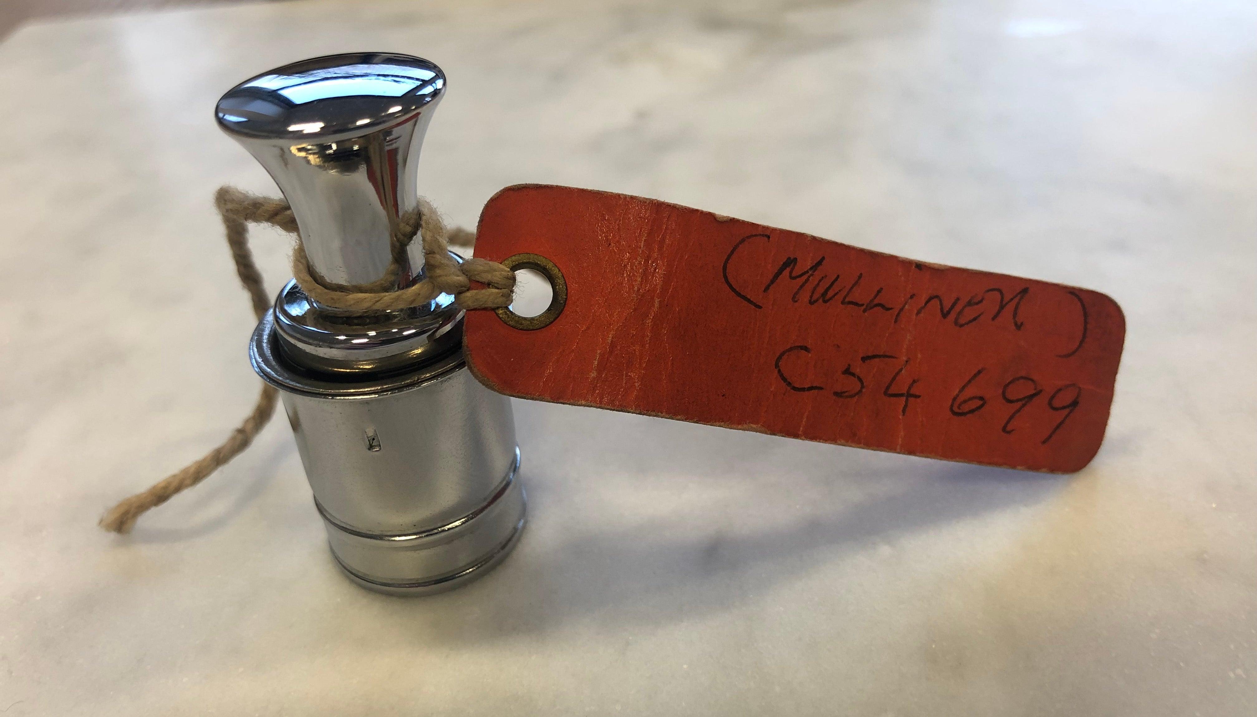 A cigarette lighter from John Lennon’s celebrated white Rolls-Royce Phantom 5
Signed handsomely by Lennon on the attached tag
Gifted by Lennon to a mechanic friend in the late 1960s

A silver car lighter from John Lennon’s celebrated white