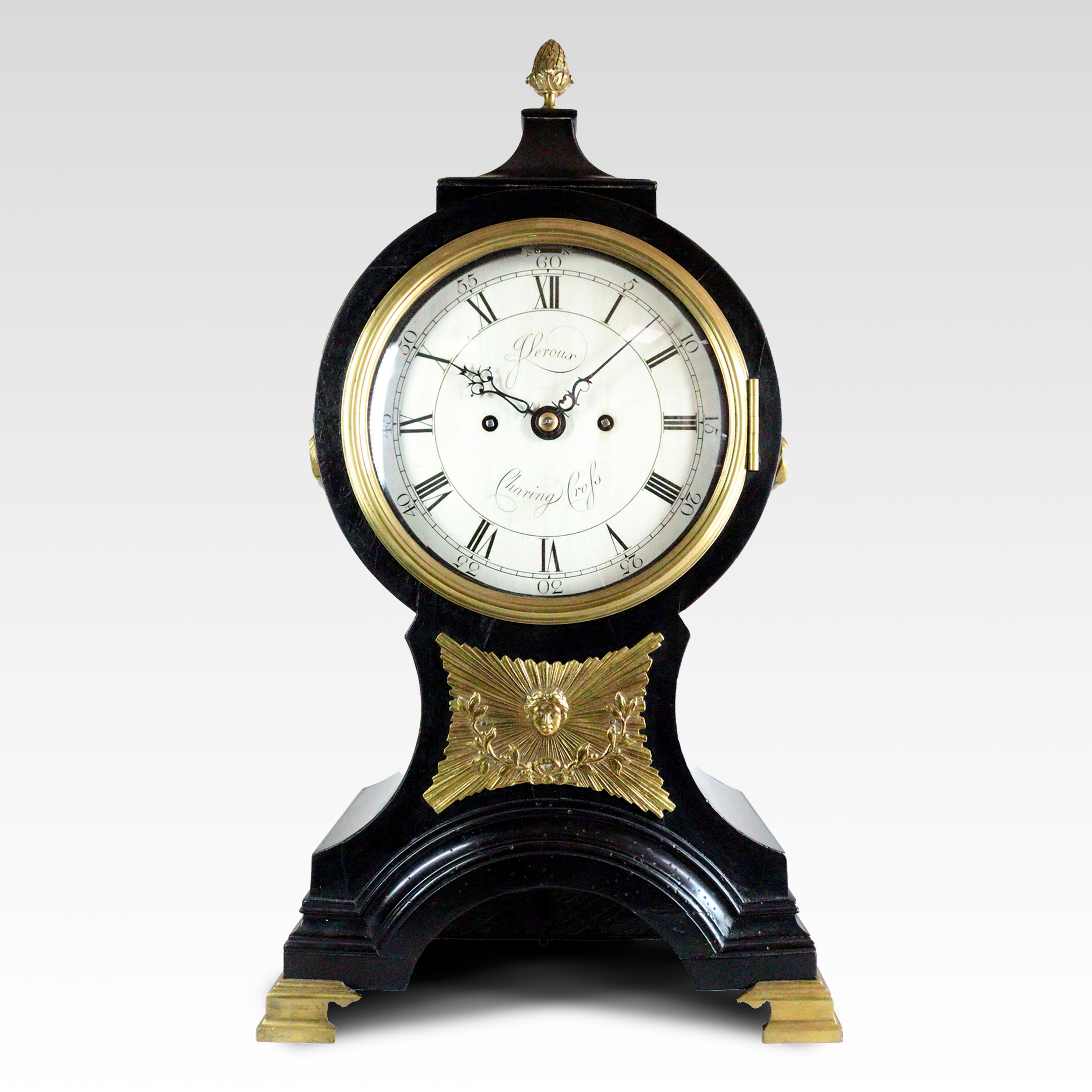 An 18th century balloon shaped bracket or table clock by John Leroux of Charing Cross, dating from circa 1790. The waisted case surmounted by a brass pineapple finial over a drum housing the movement. The dial is behind a hinged convex glazed cast