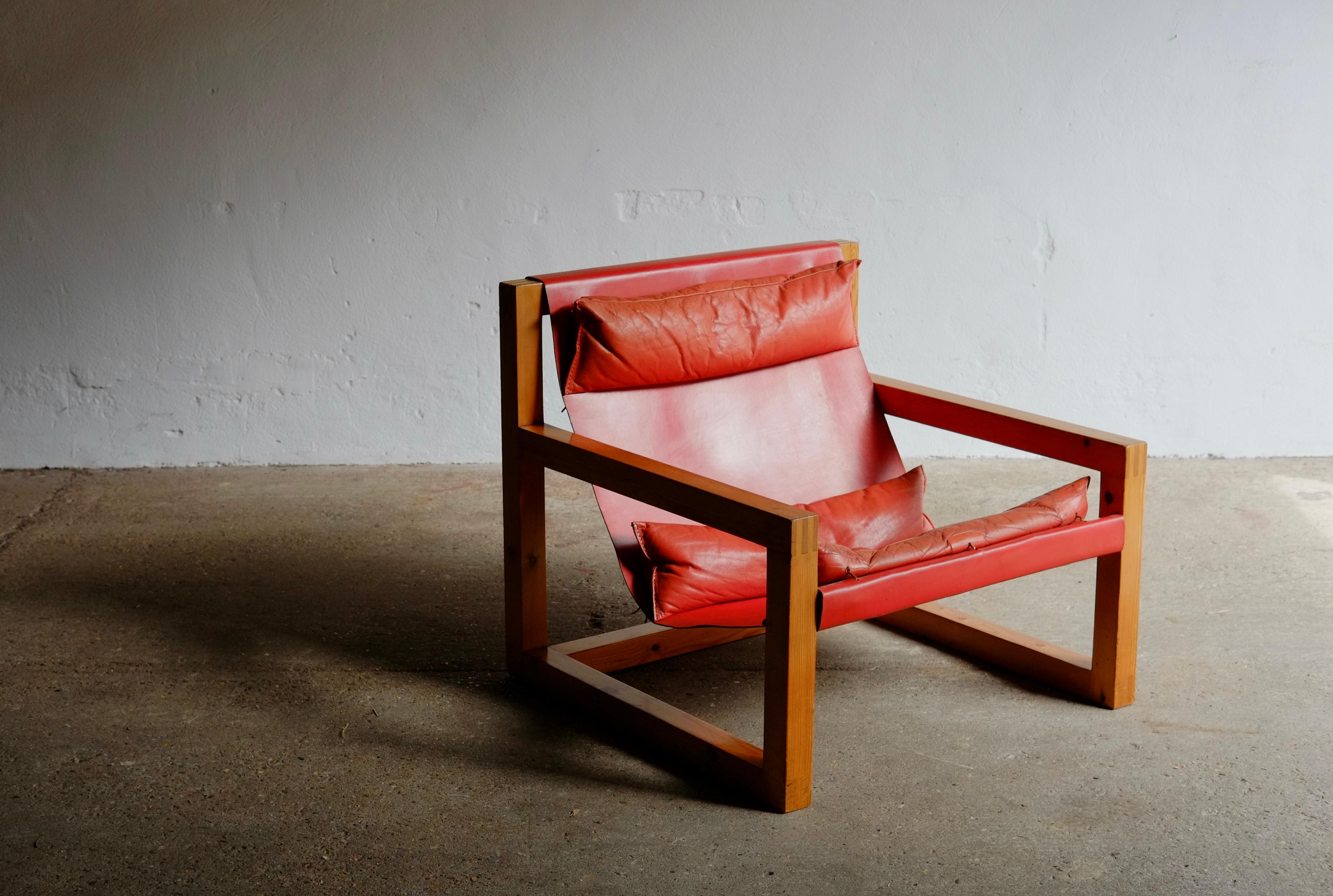 A rare red leather sling lounge chair designed by British designer John Makepeace (OBE) and produced in the 1970's by Liberty & Co.

Pine frame with a red leather seat and three matching supporting cushions. The chair is in good solid vintage