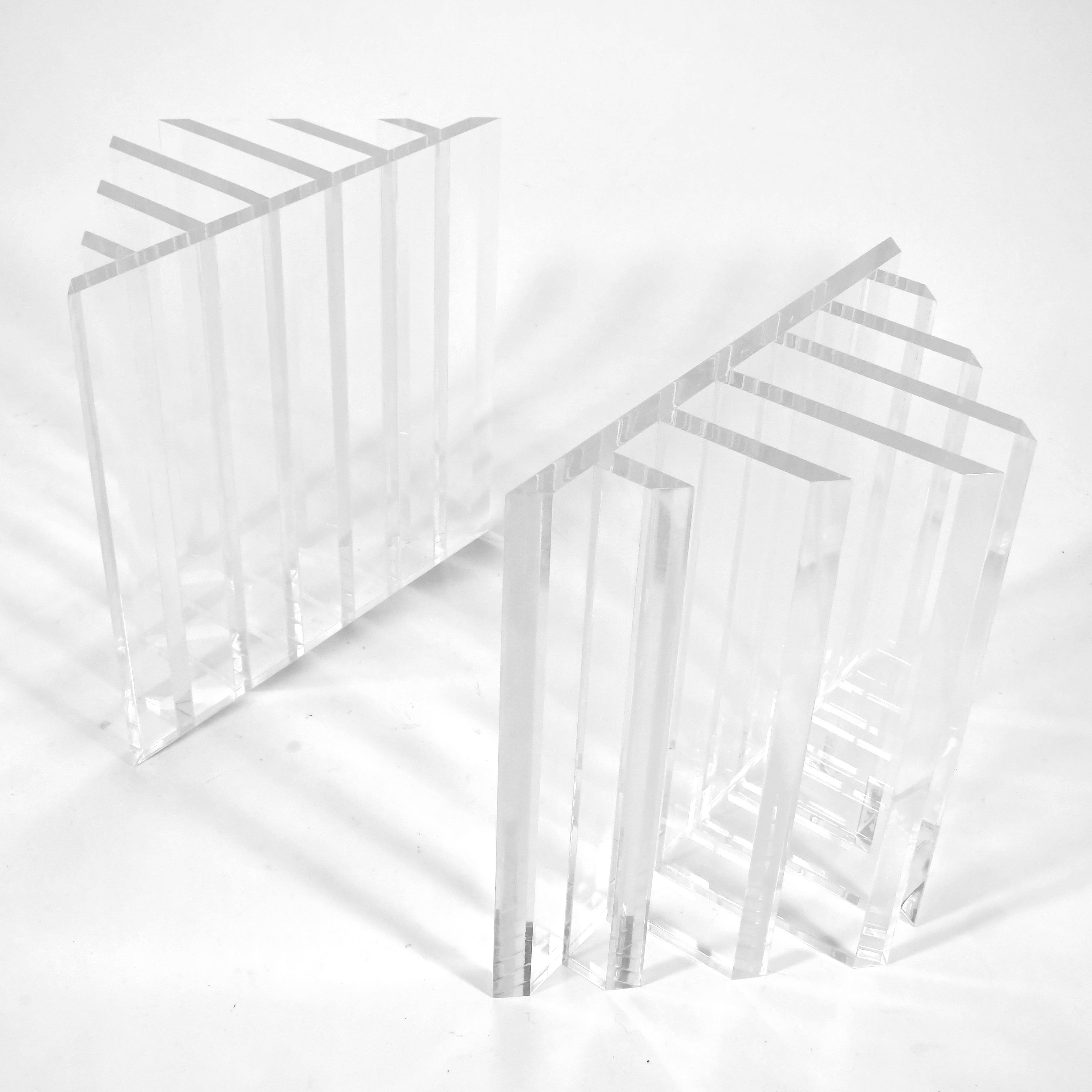 Cette paire de piédestaux de table dynamiques de John Mascheroni présente un design géométrique complexe exécuté en Lucite épaisse. Les deux bases peuvent être disposées selon différentes configurations et sont capables de supporter un très grand