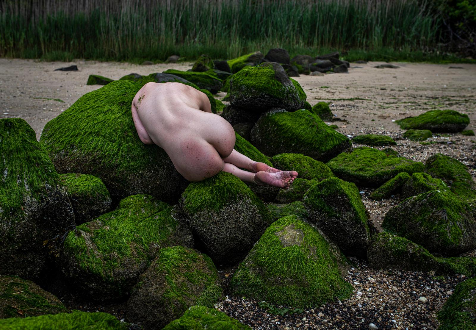 John Mazlish Color Photograph - "Body Rocks 1, Color"- Moody Nude Photo Shot in the Rain on a Beach