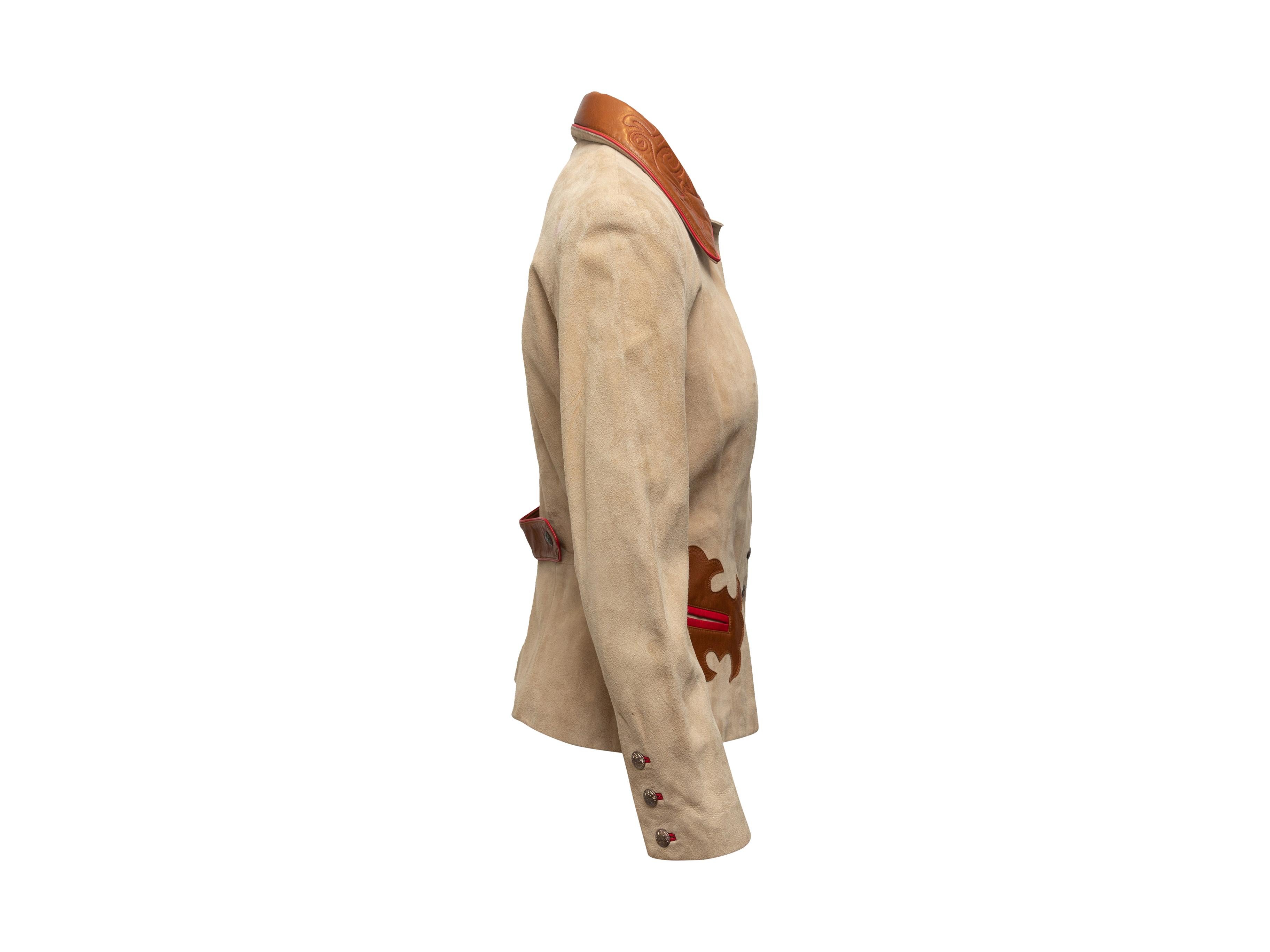 Product details: Vintage tan suede and brown leather western jacket by John Michael. Pointed collar featuring embroidery. Dual welt pockets at hips. Button closures at front. 19