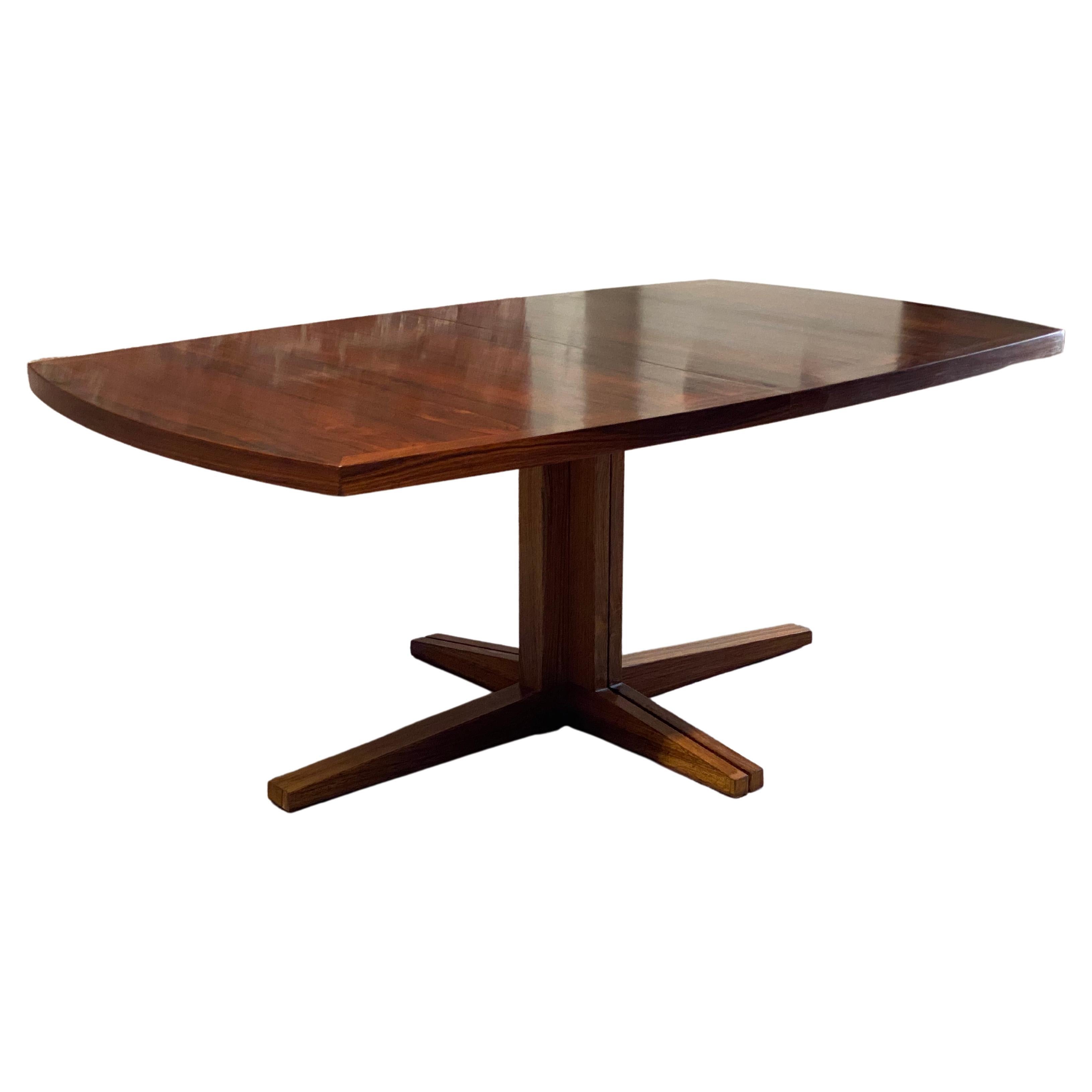 John Mortensen for Heltborg Møbler Danish Modern Rosewood dining table with two leaves. Beautifully figured Rosewood veneers. Extends easily to accommodate one leaf or two large leaves. Rectangular top with curved sides. Split pedestal base. Circa