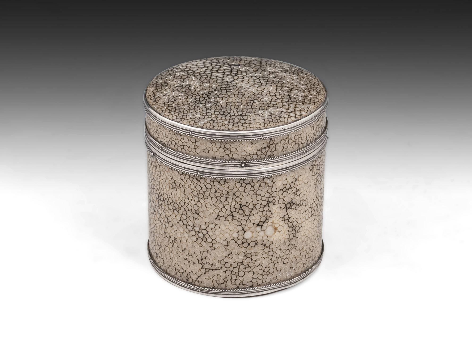 Cylindrical shagreen box and cover by John Paul Cooper, made from walnut, covered with shagreen and finished with applied engraved silver bands and rope twisted mounts. The underside of the removable lid features a small silver plaque which reads “J