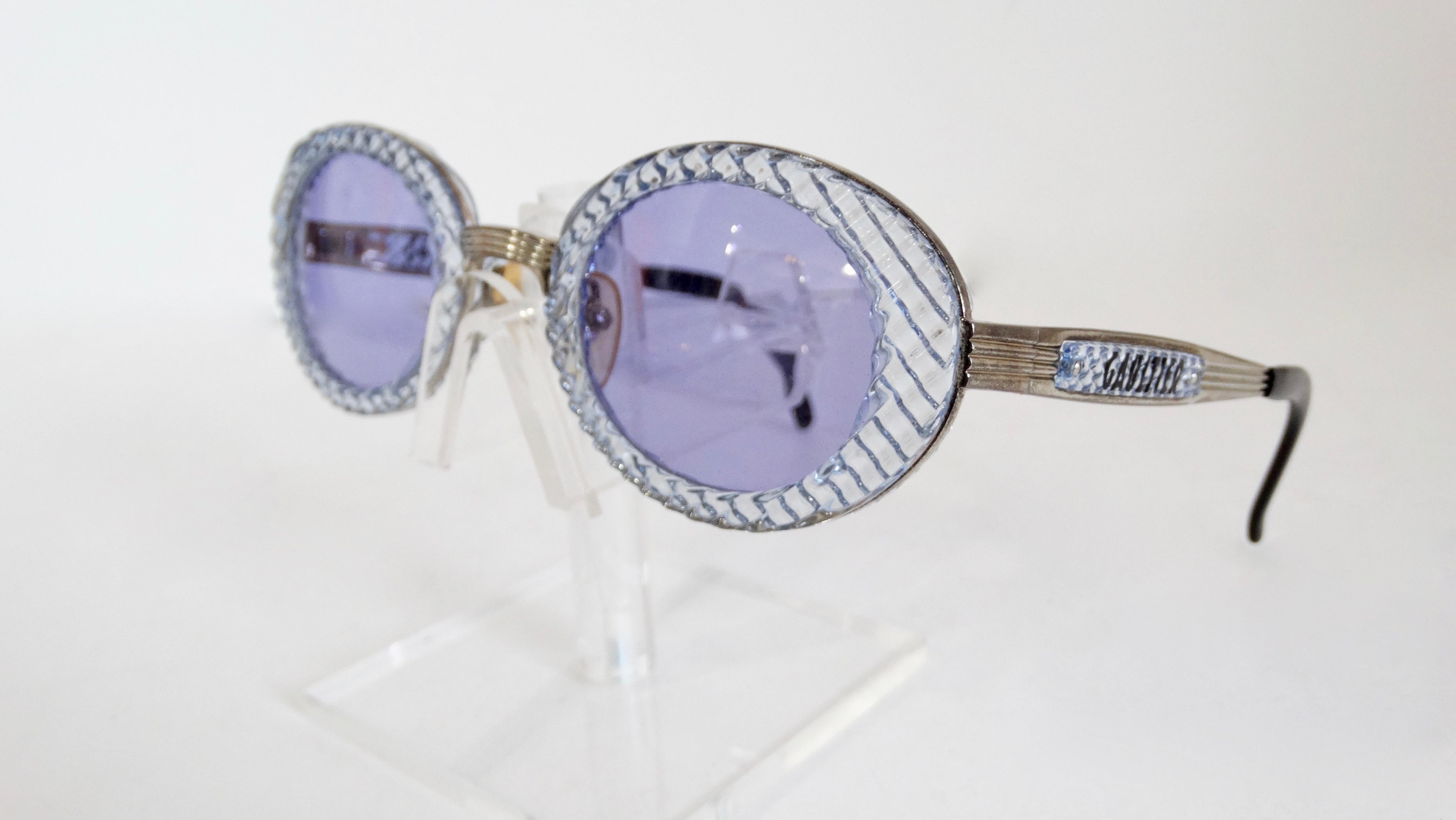 Elevate your look with these very rare John Paul Gaultier sunglasses! Circa 1990s, these sunglasses feature a translucent blue textured oval frame with blue tinted lenses. Includes silver plated hardware with 'Gaultier' on the sides. The ultimate