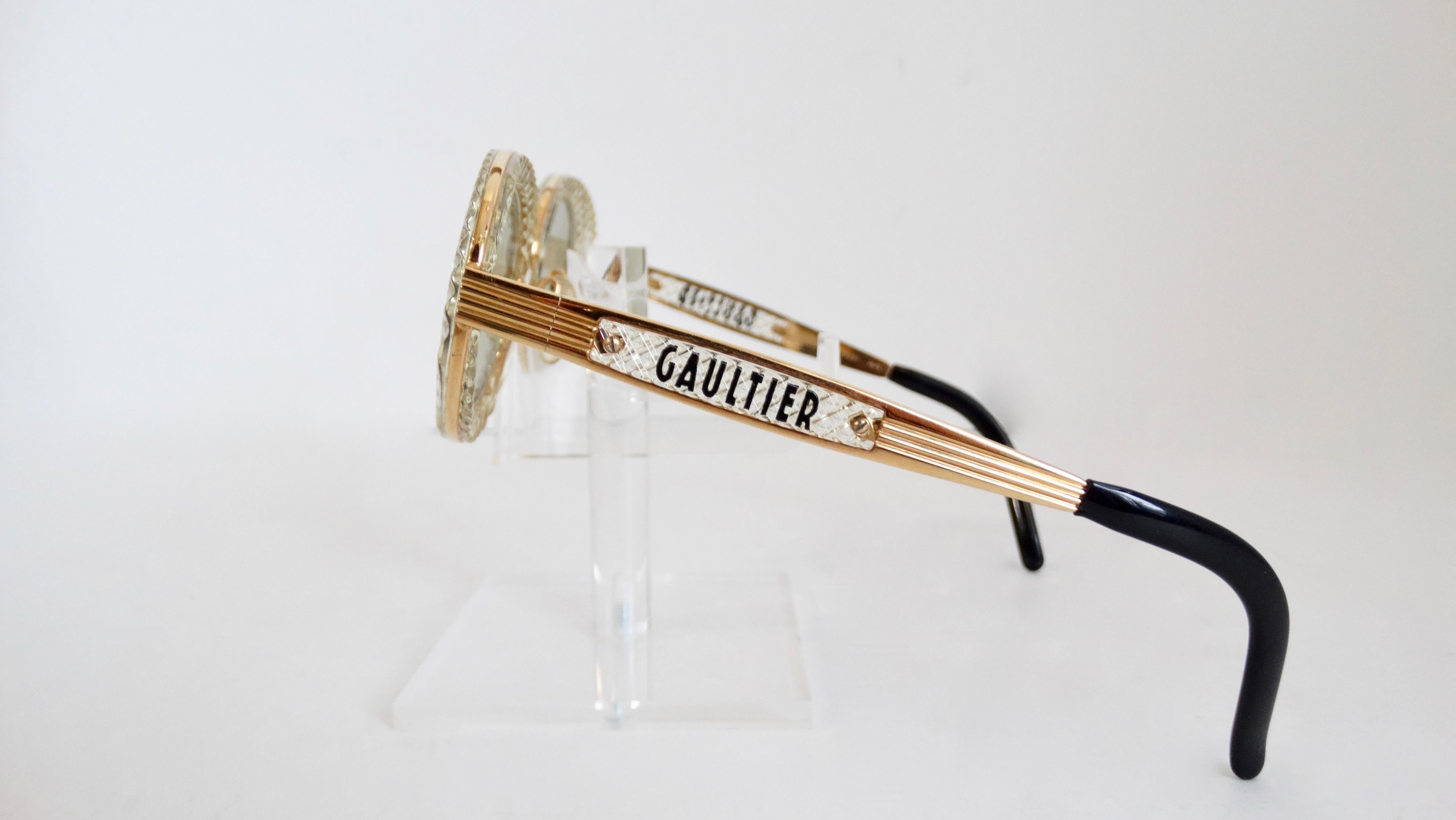 Elevate your look with these very rare John Paul Gaultier sunglasses! Circa 1990s, these sunglasses feature a translucent gold textured oval frame with light green lenses. Includes gold plated hardware with 'Gaultier' on the sides. The ultimate pair