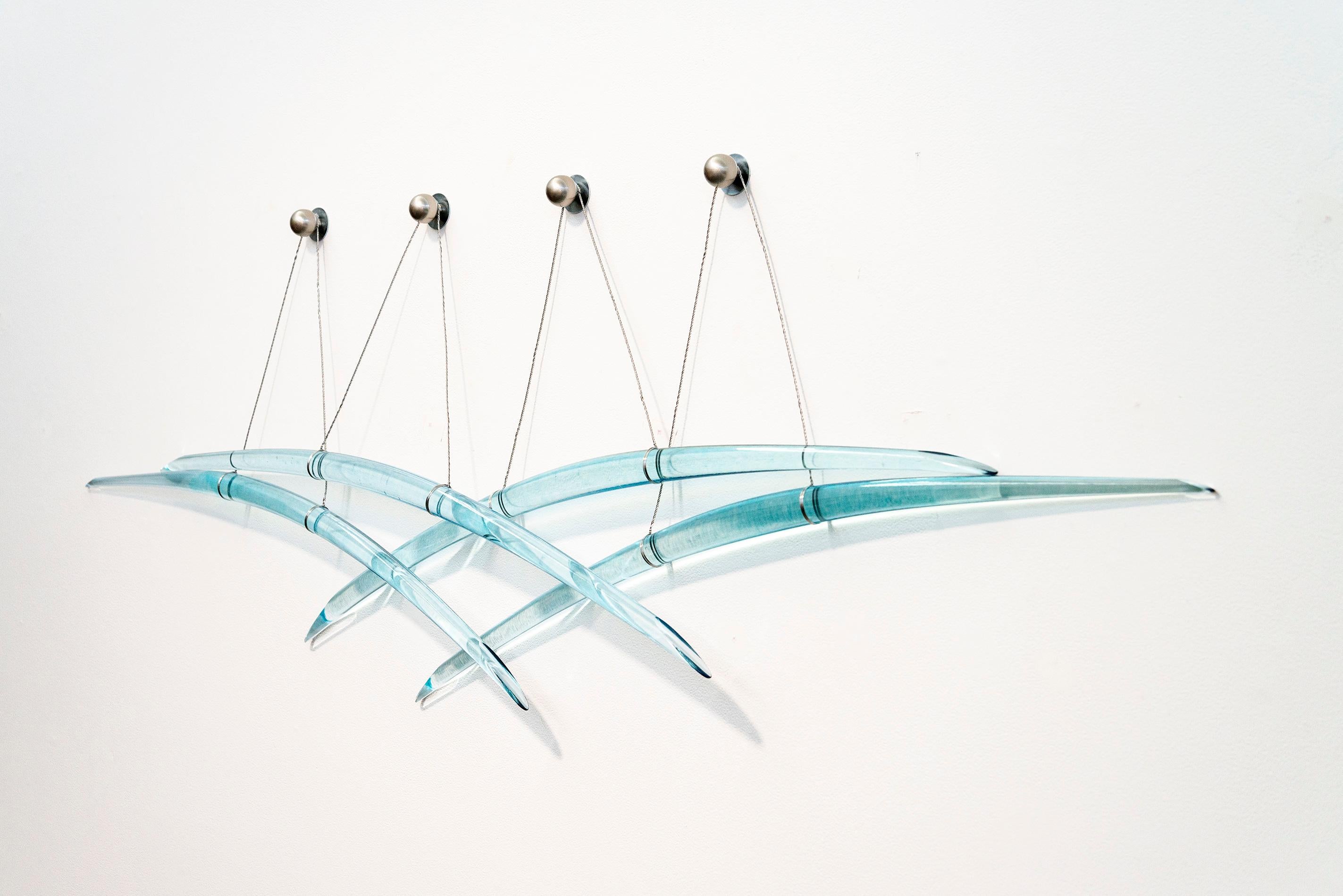 Diese blaue, abstrakte, zeitgenössische Wandskulptur aus Glas und Stahl ist ein Werk des kanadischen Künstlers John Paul Robinson. Elegant und ätherisch reflektieren John Paul Robinsons zeitgenössische Wandskulpturen aus Glas das Licht und werfen