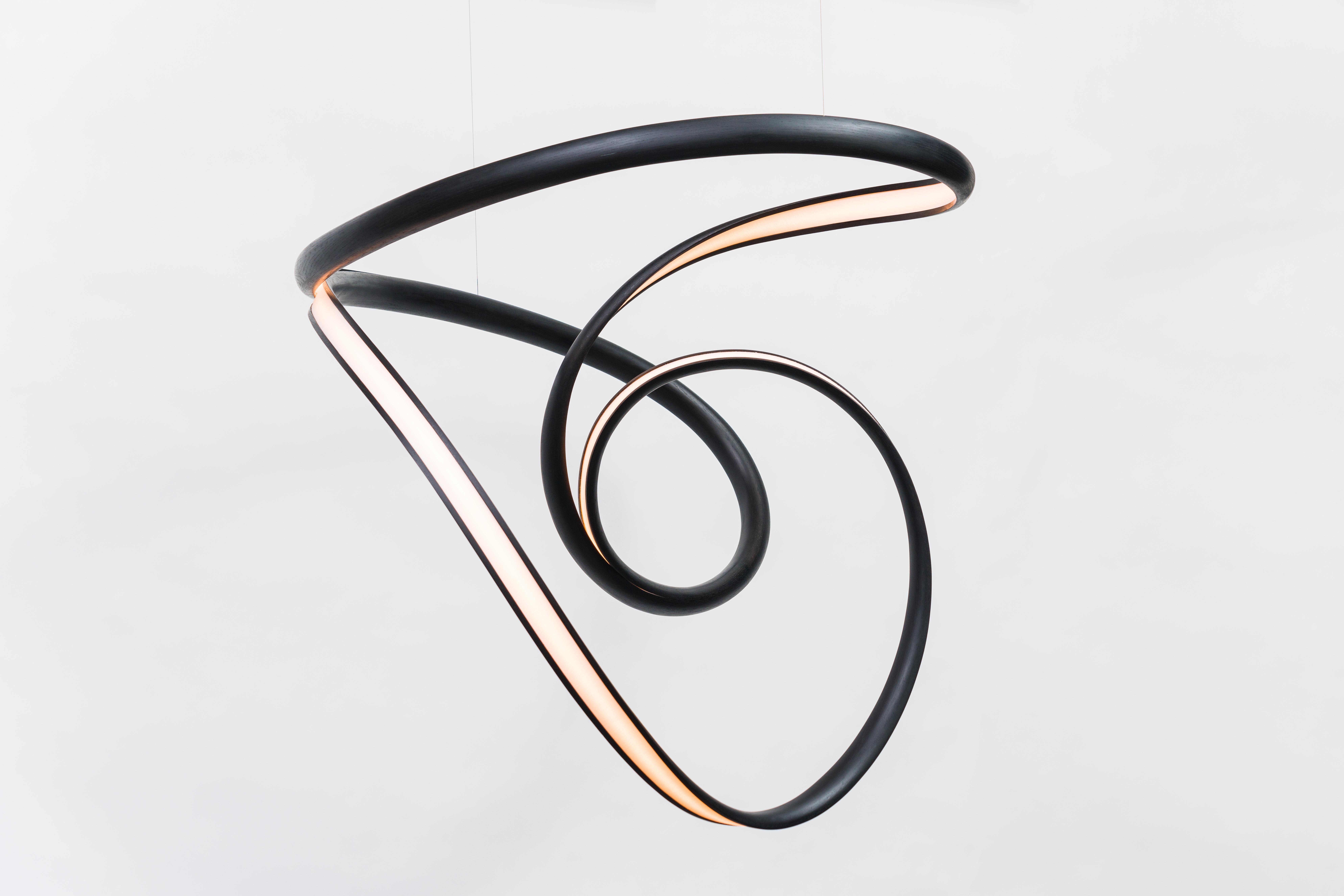 Procario’s sculptural lighting is composed of micro-laminated wood fused with LEDs. With a rough sketch in his mind, Procario freeform bends the wood into one of his signature undulating shapes. After months spent intentionally breaking wood—whether