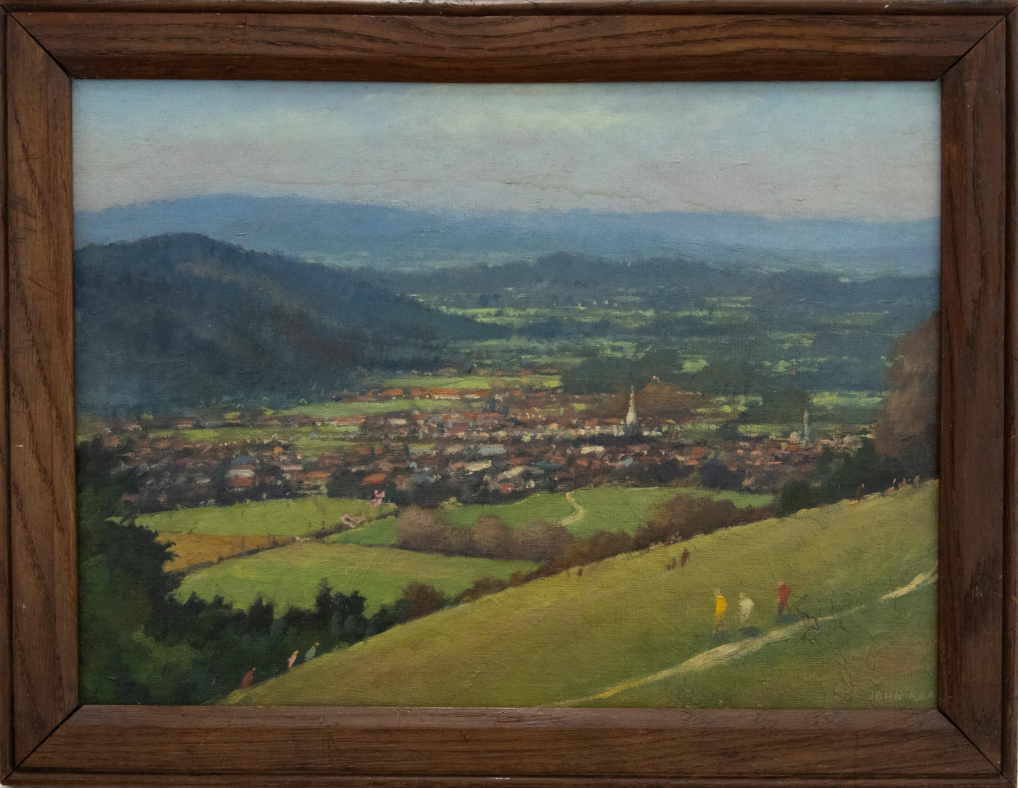 A delightful panoramic landscape of a small English village. Figures walk up and down a steep hill in the foreground while mountains surround the composition. Well presented in a simple wood frame. Signed to the lower right. On canvas board.