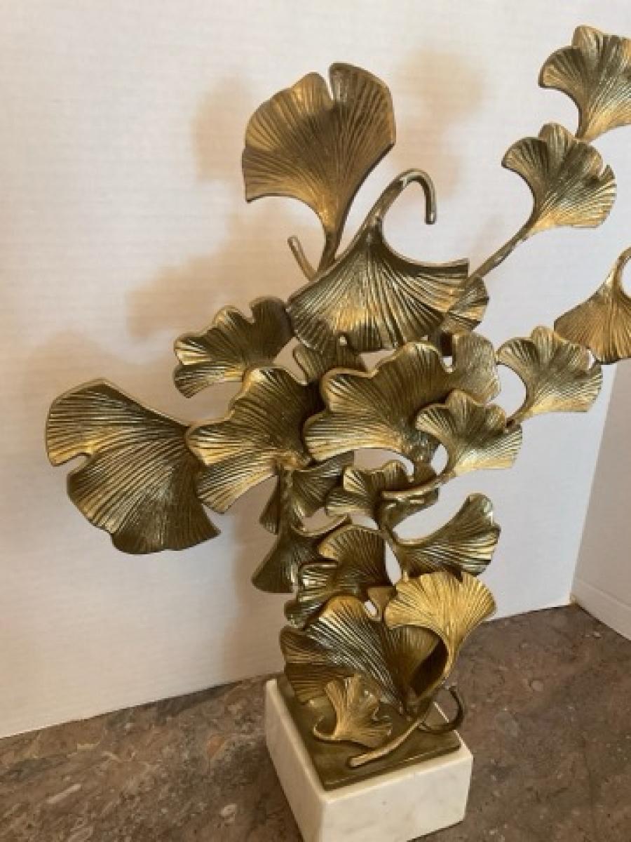 Questa inserzione presenta una scultura di foglie di Gingko in ottone che poggia su una base di marmo. Le foglie di Gingko provengono da un albero di Gingko biloba, comunemente usato come integratore alimentare.

Fondata nel 1980 a Greenwood, nel