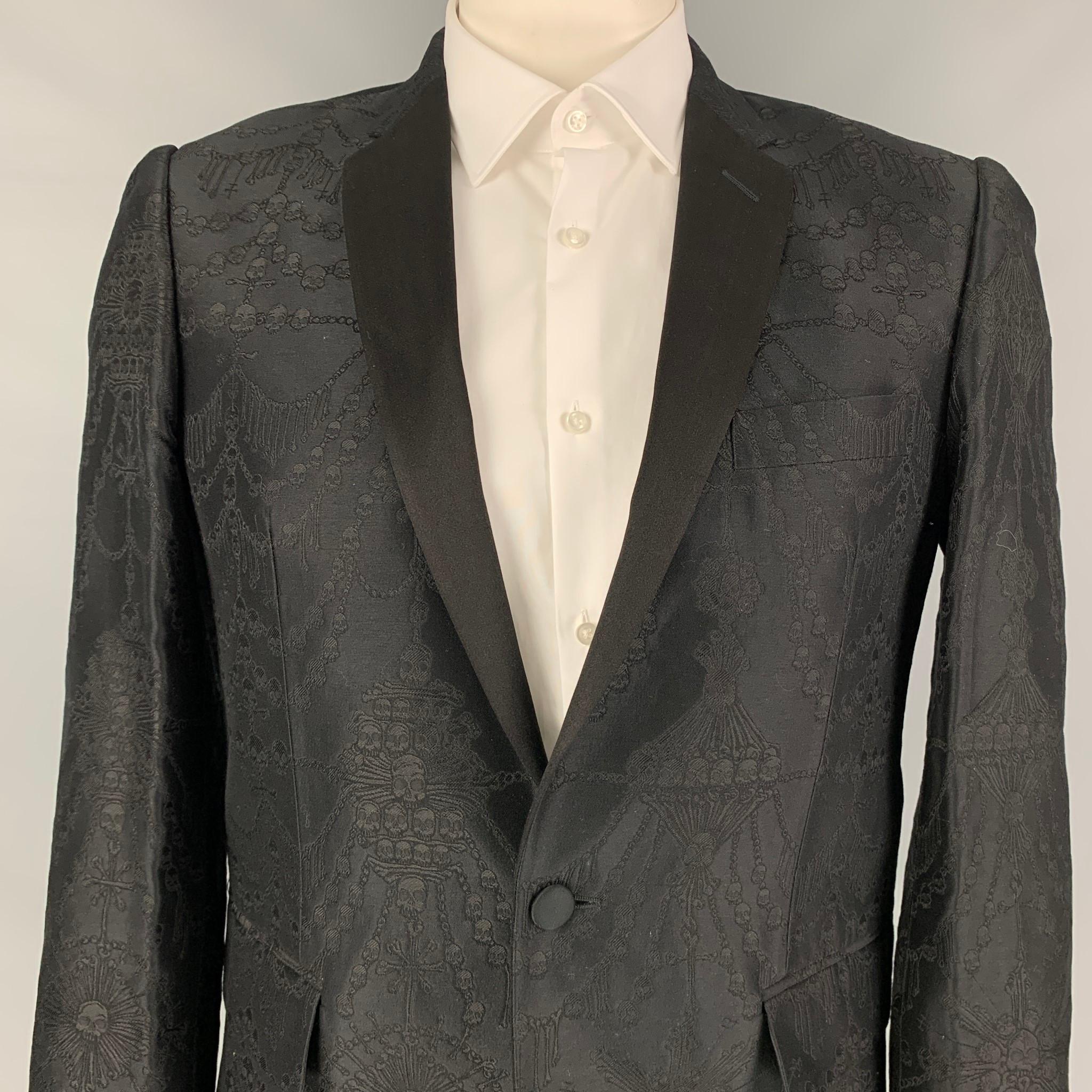 JOHN RICHMOND sport coat comes in a black skull jacquard cotton blend with a full liner featuring a notch lapel, flap pockets, single back vent, and a single button closure. Made in Italy. 

Excellent Pre-Owned Condition.
Marked: