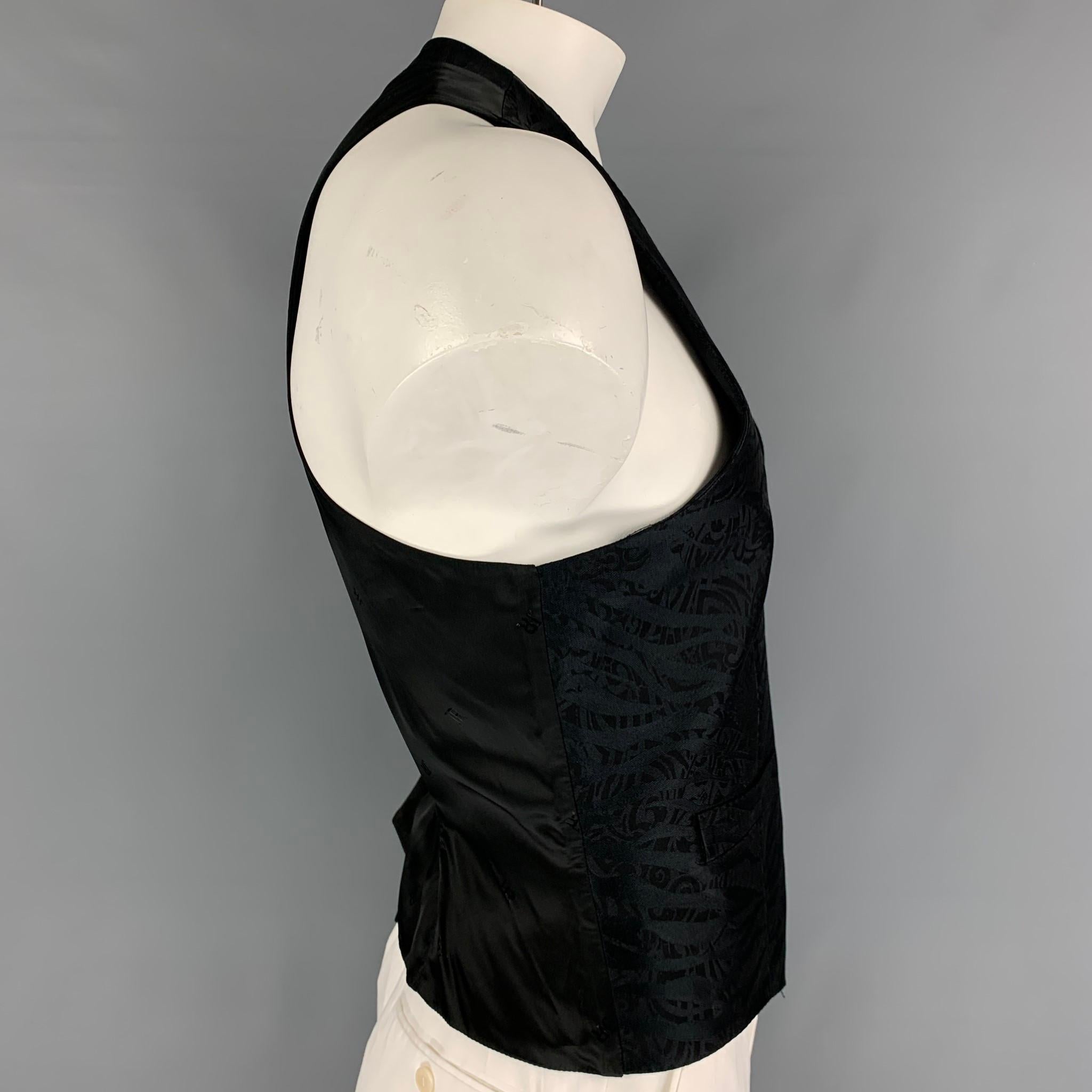 JOHN RICHMOND dress vest comes in a black jacquard polyester blend featuring a back belt, front pockets, and a buttoned closure. 

Very Good Pre-Owned Condition.
Marked: 54

Measurements:

Shoulder: 13.5 in.
Chest: 44 in.
Length: 22 in. 