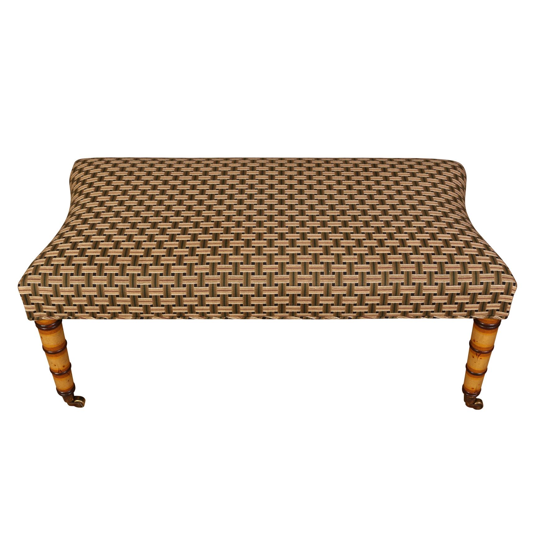 A vintage John Rosselli faux bamboo bench with a basketweave design upholstered seat and casters to the feet.