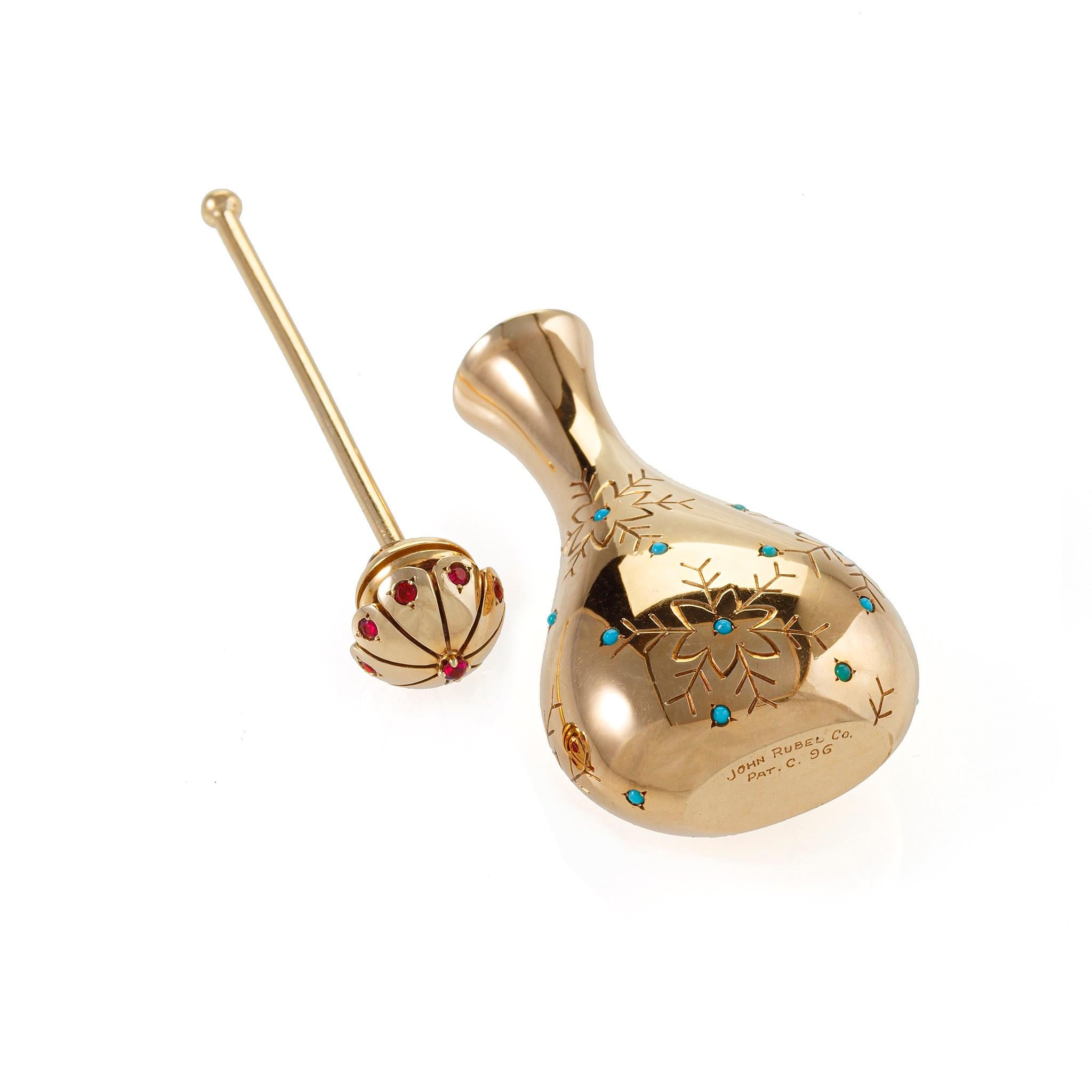 Dating from the 1940s, this 14K gold perfume or scent bottle is set with rubies and turquoise. It is designed as a pear-shaped form inspired by Persian rosewater flasks, with stylized engraved blossom motifs highlighted by cabochon turquoise, the