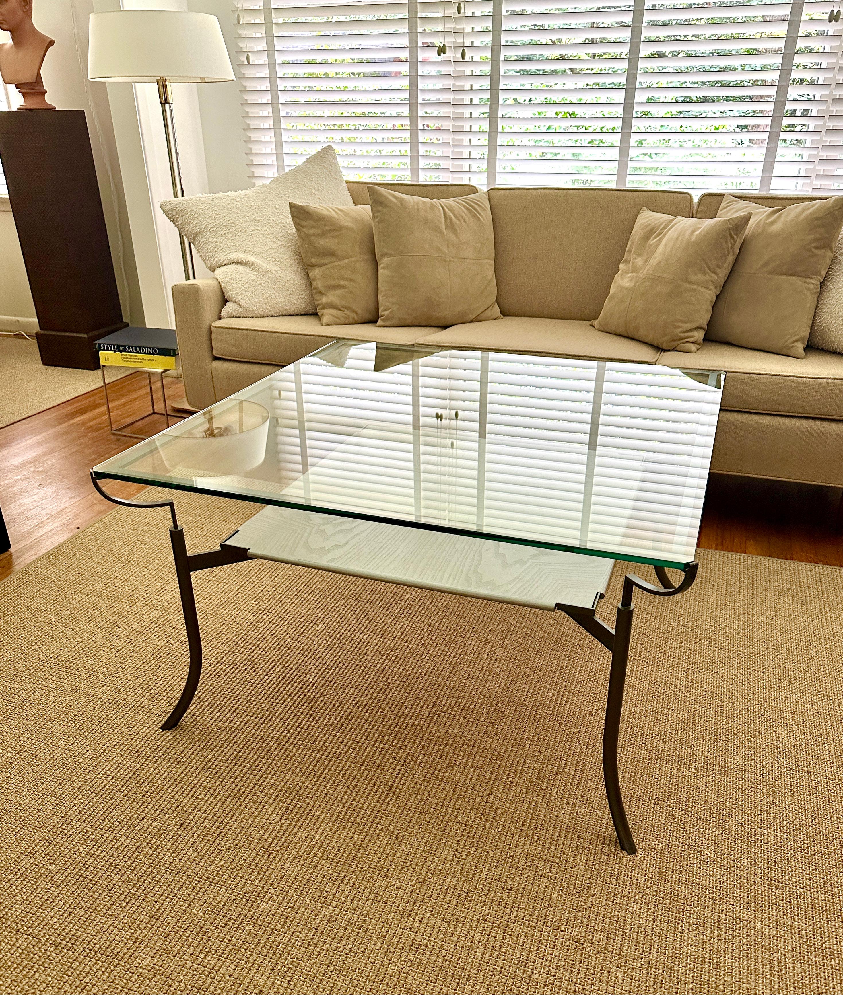 Coffee table designed by John Saladino, named “The Quadrant Coffee Table”, model number 402, from about 2005. The table base is of a low-carbon steel construction in a gray metallic finish, 3/8” clear (non-tempered) glass top and a wood bottom tray
