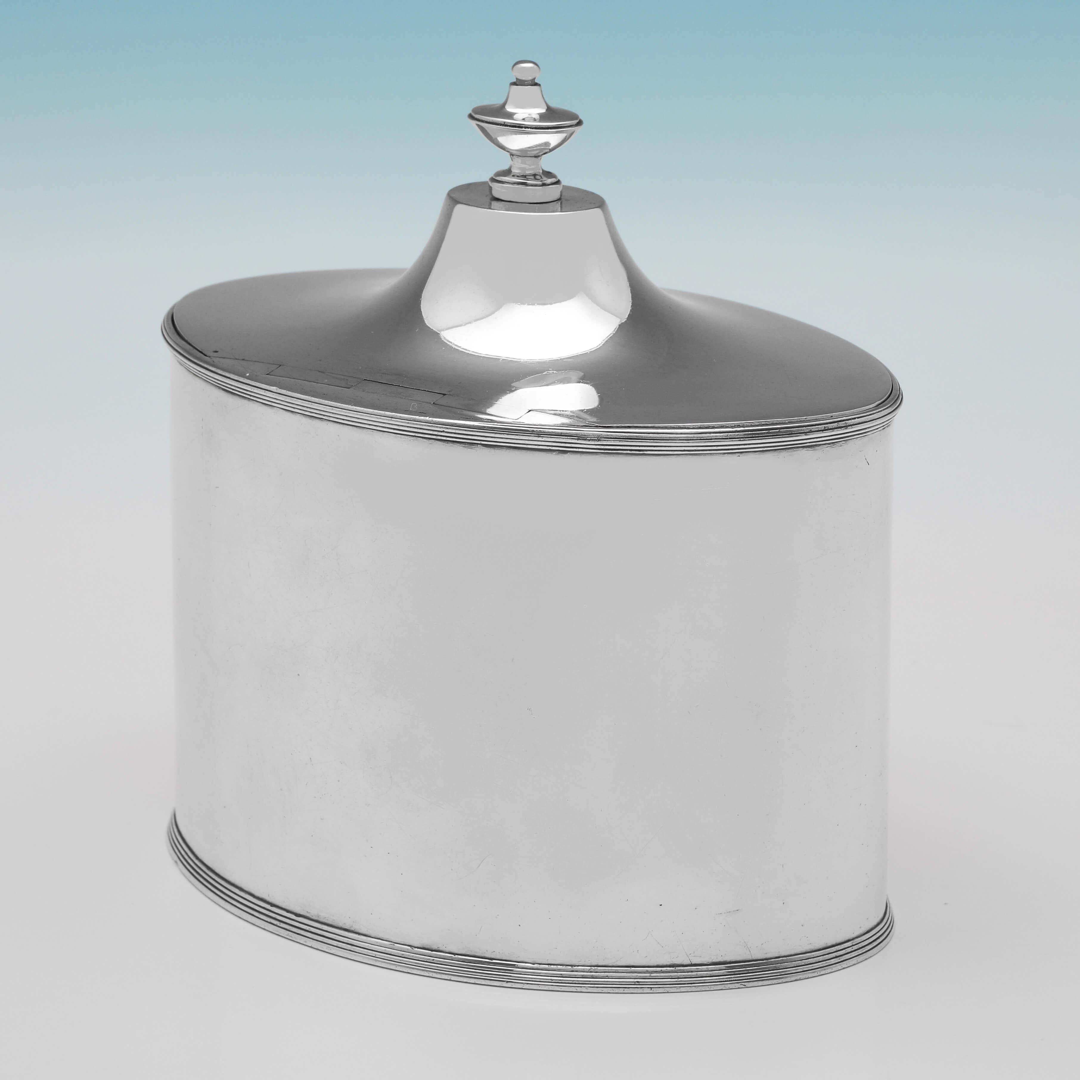 Hallmarked in London in 1792 by John Scofield, this very handsome, George III, Antique Sterling Silver Tea Caddy, is oval in shape, plain in style, and features reed detailing. The tea caddy measures 5.75