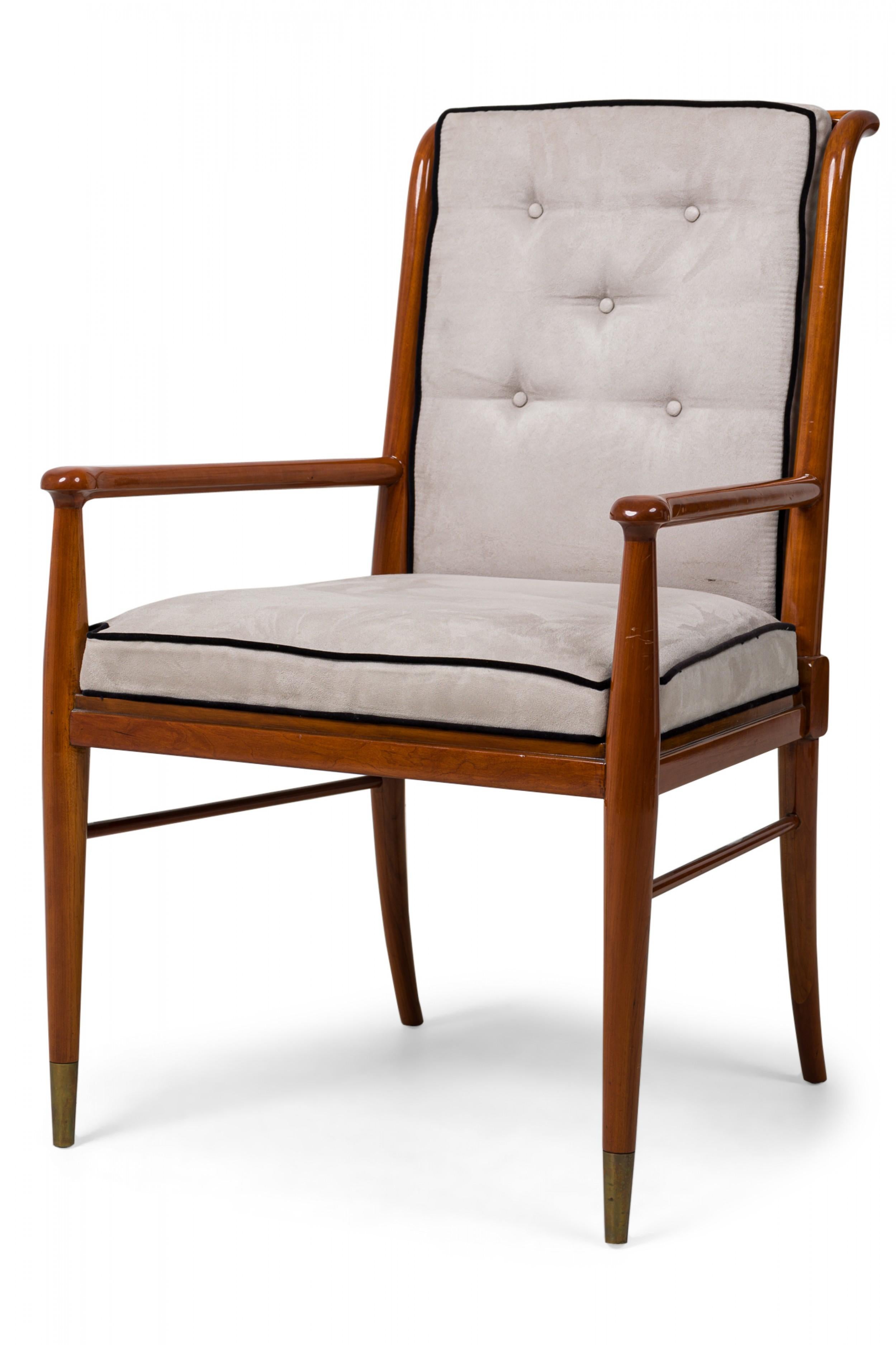 Mid-Century American (1950s) walnut armchair featuring a curved back with 5 pierced slats on sabre back legs, gray suede upholstered back and seat, button tufted with black piping, plus 2 horizontal stretchers and brass sabots on the front legs.