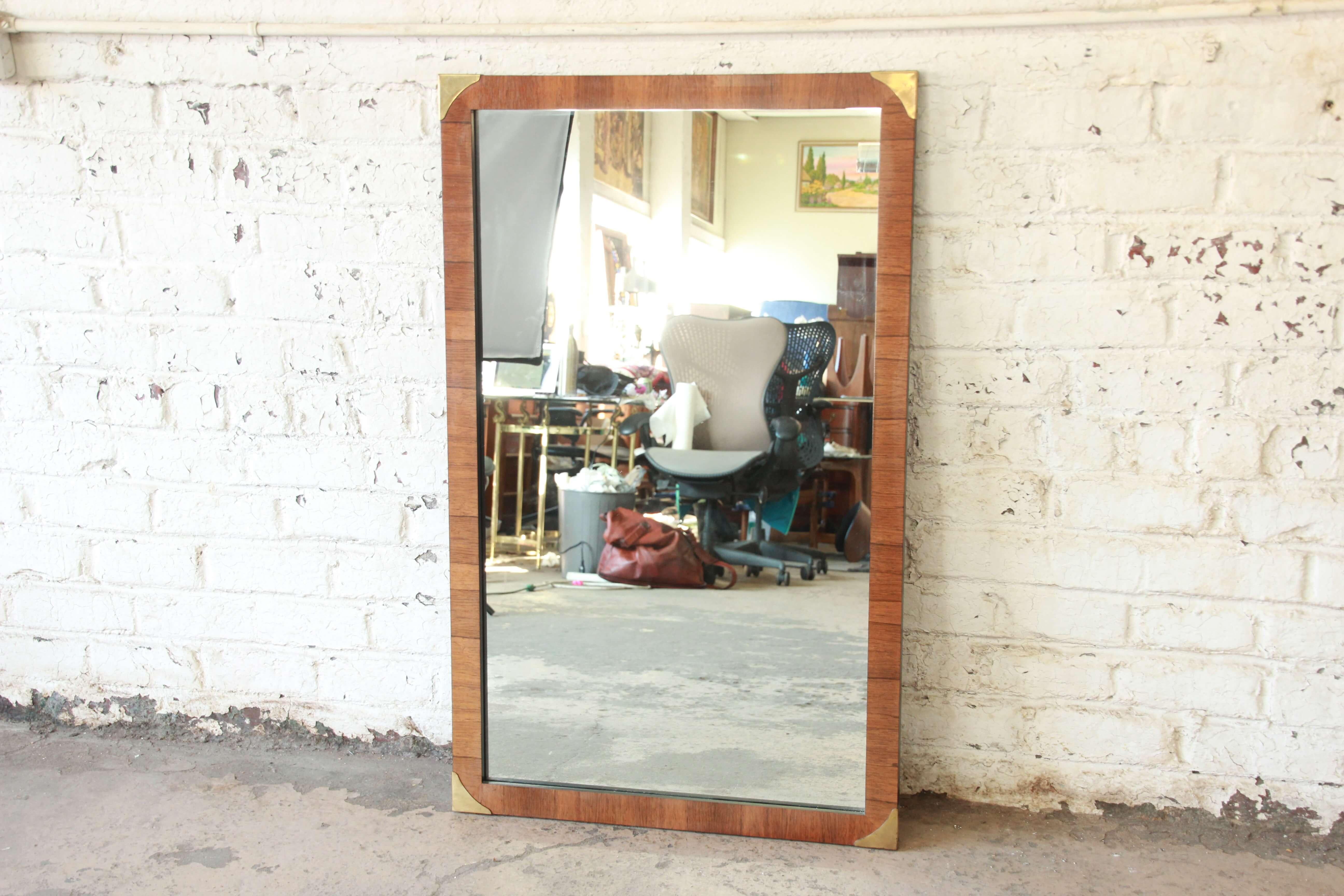 Offering a very nice rosewood and brass mirror. The mirror has a beautiful rosewood veneer frame with brass corners. The mirror is clear and in great vintage condition.