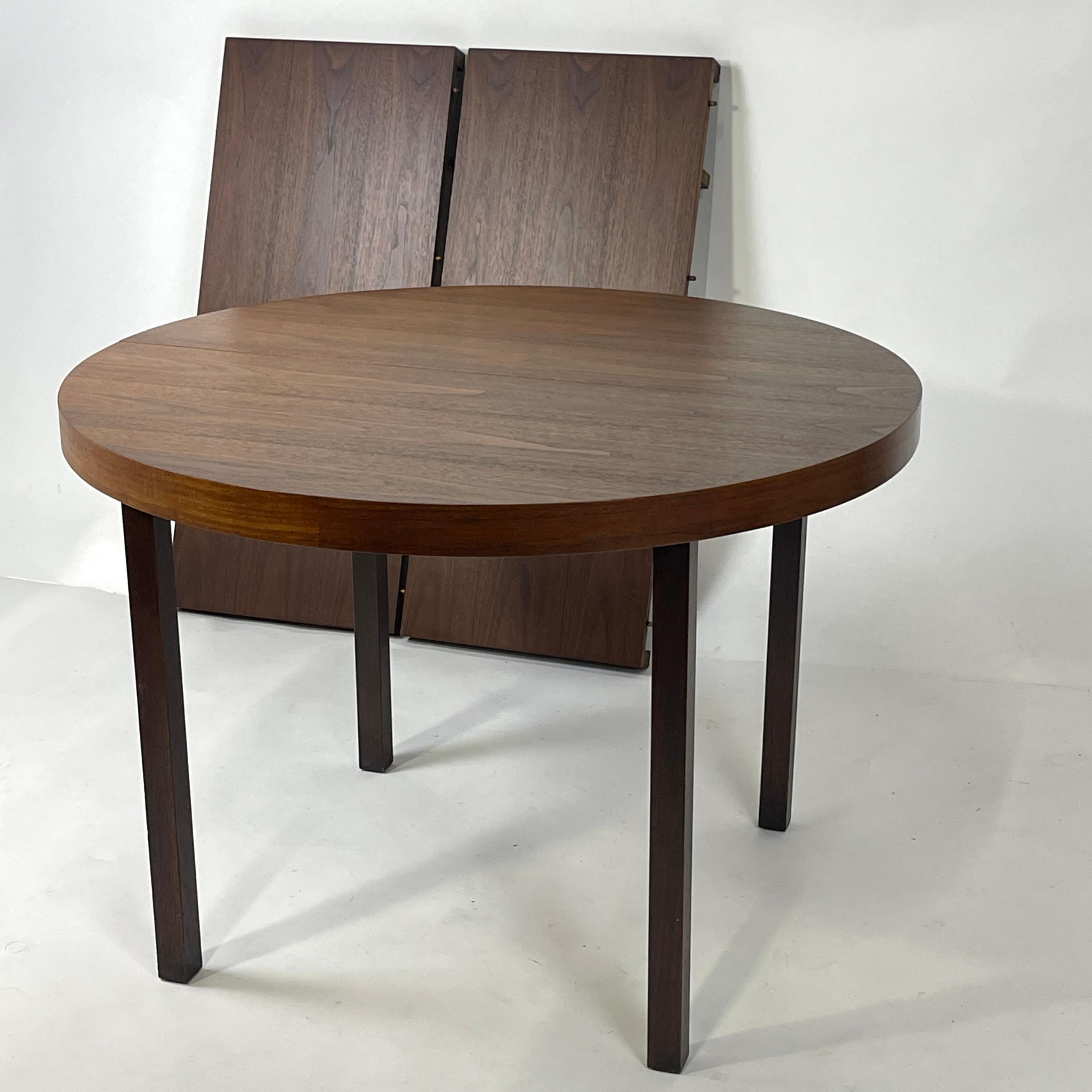 Un tavolo da pranzo assolutamente straordinario di JOHN STUART INC. Straordinario produttore e distributore di mobili di pregio della metà del secolo scorso.
Il piano del tavolo rotondo e le foglie sono in noce, mentre le gambe sono in mogano