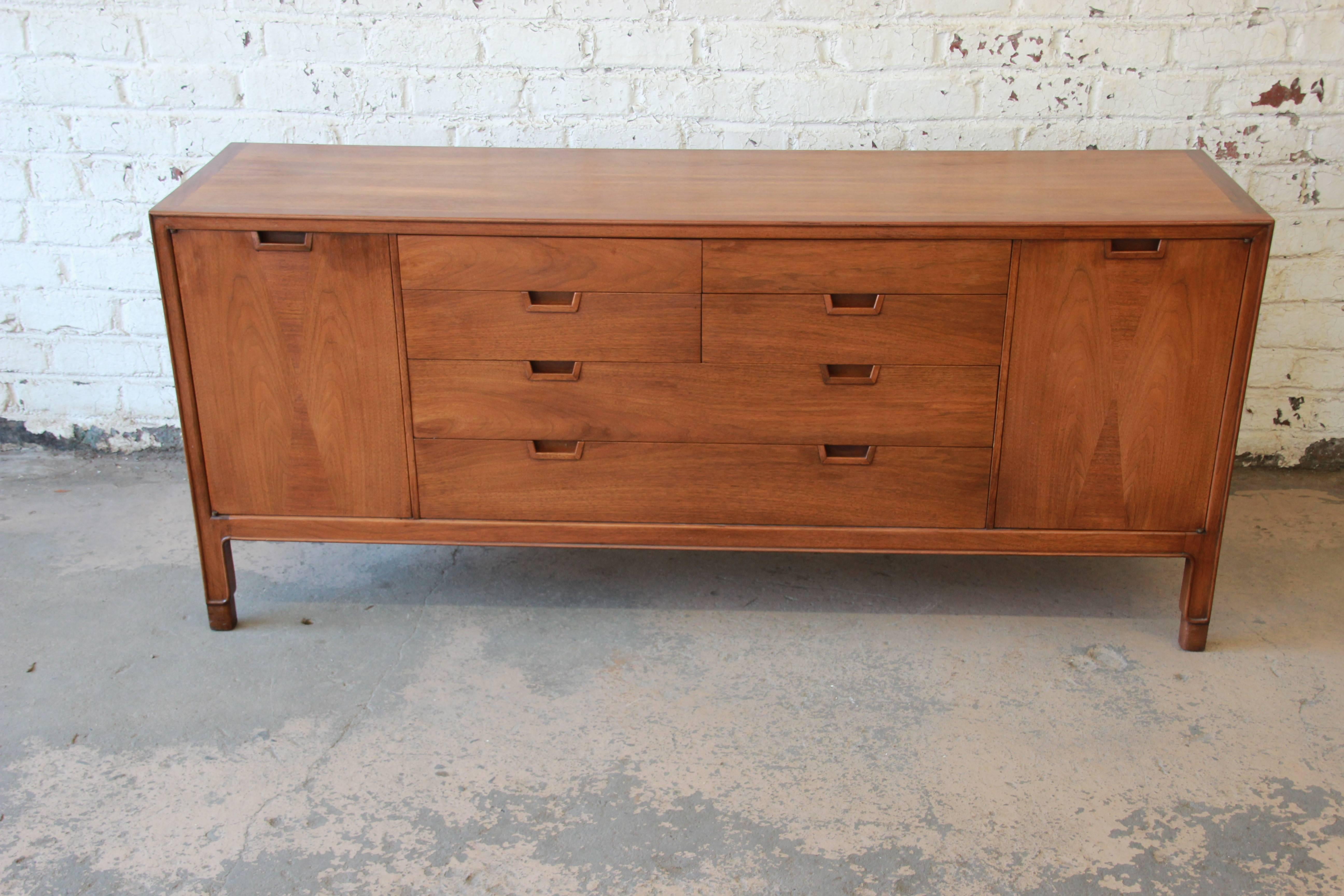 Offering a very nice unique fourteen drawer dresser or credenza by Mt. Airy. The dresser is apart of the Janus collection and is made from walnut with an inlaid wood design on the cabinet doors. The doors open each open up to four smooth sliding