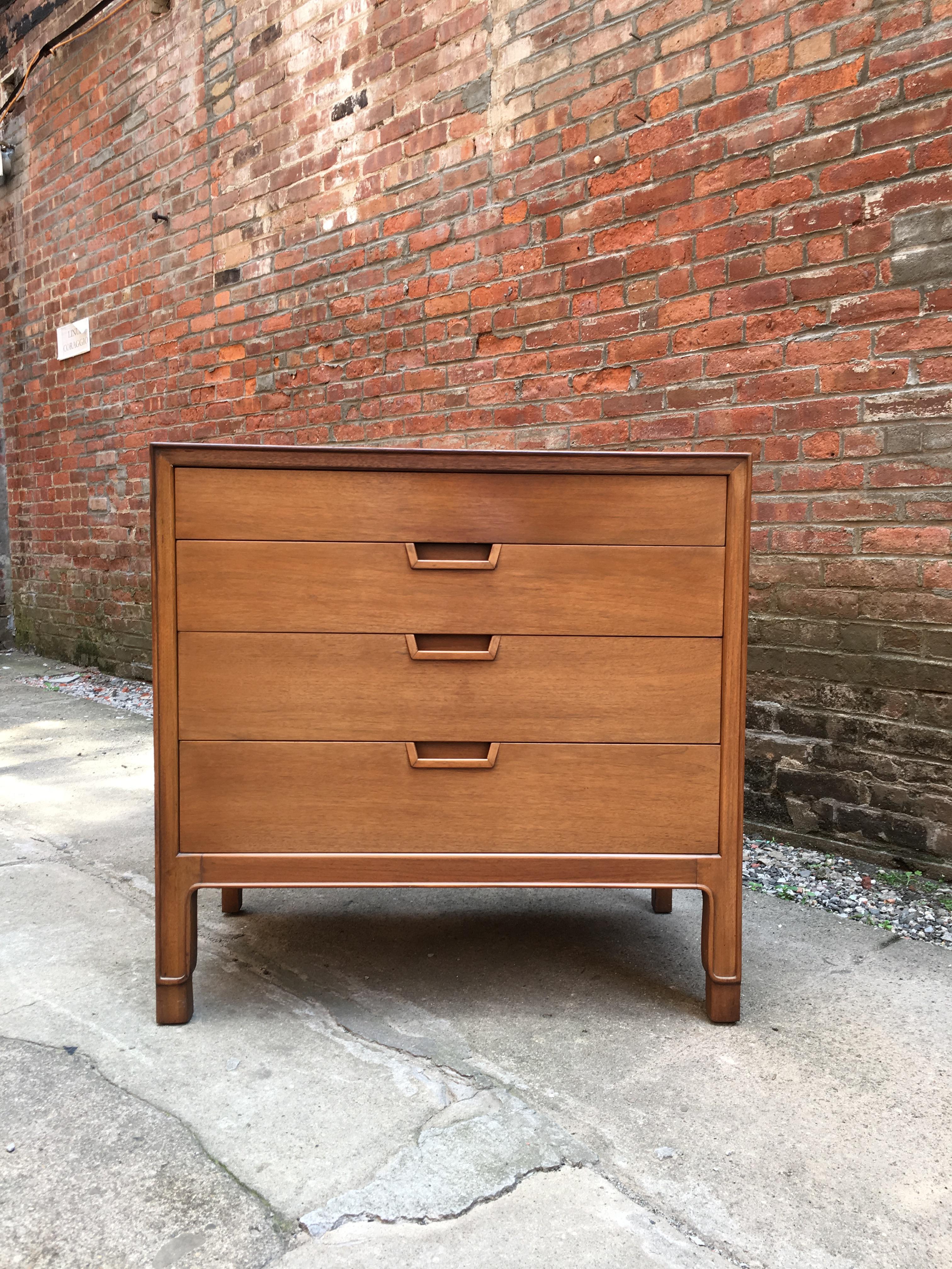 Beautiful solid and veneer walnut construction, circa 1955-1960. Four drawers on nicely carved legs. Banded veneer edge on top. Recessed handles. Oak secondary wood. Signed with burn in Janus stamp. Nice original condition. Missing the enamel John